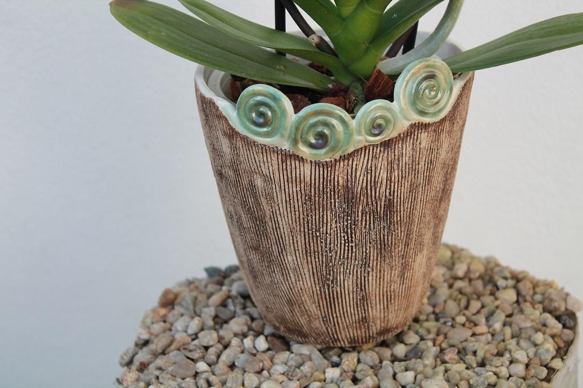Simone Winkler-Thies Keramik aus Pankow zeigt einen Übertopf für Zimmerpflanzen, erdfarben, in Spiralen grün auslaufend.