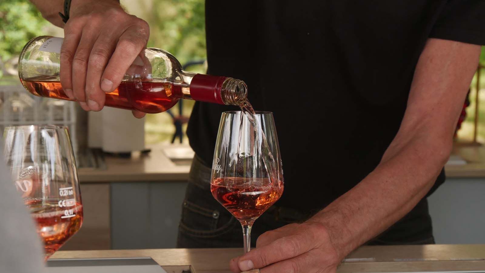 Genießen bei Pfingsten in der Preußenallee Sich ein Glas Wein einschenken lassen am Weinstand vom italienischen Weinbauern