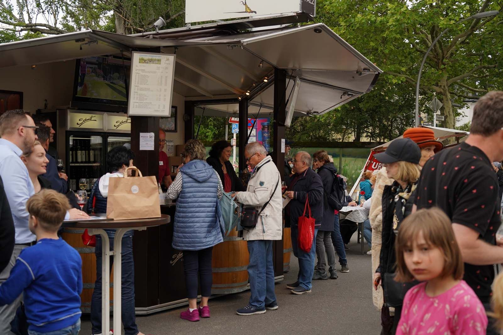 Am Weinwagen des Weinguts Schmitt aus Ilbesheim verkosten Besucher regionale Weine beim WeinPfingsten 2025 in Westend
