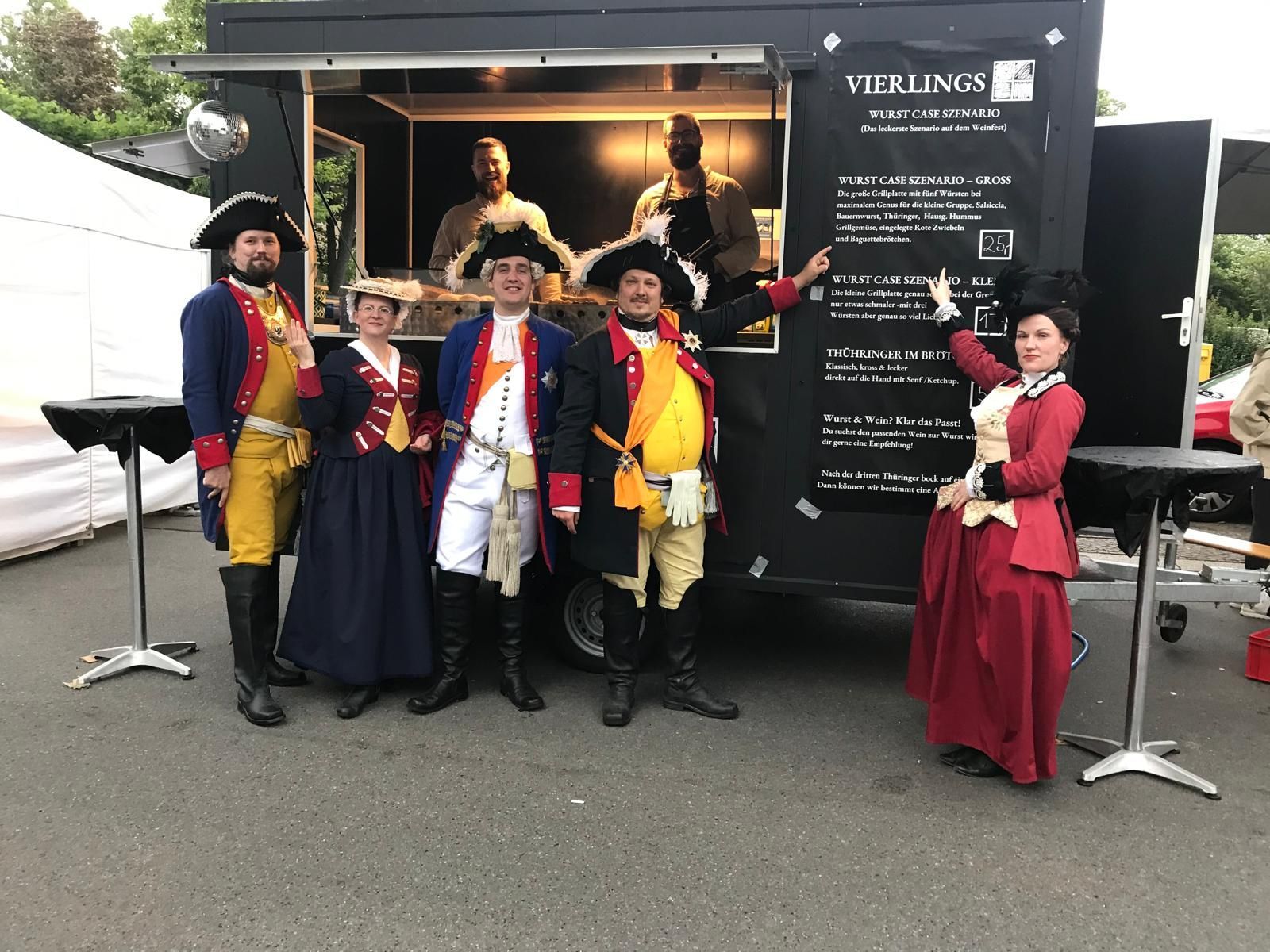 Die Höfische Gesellschaft posiert vor dem Wagen von Vierlings Catering – dankbar für das ‚Wurst-Case-Szenario‘ beim WeinPfingsten