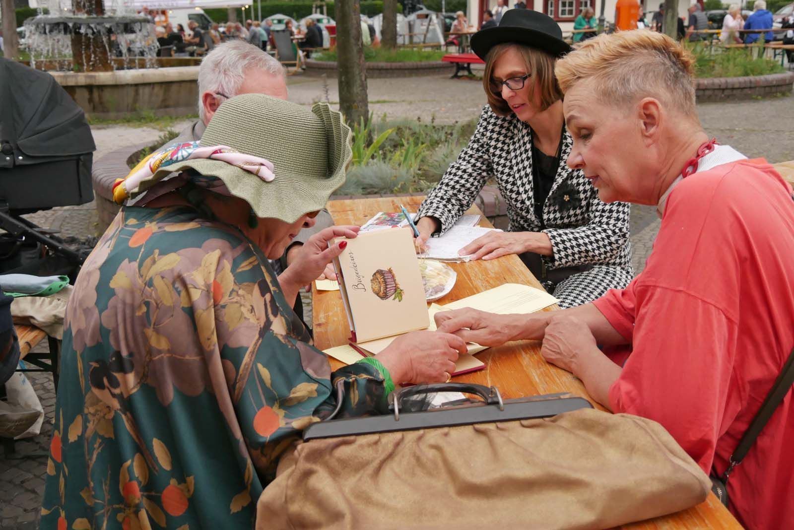 Vereinsmitglieder sitzen bei Tisch und bereiten kommende Schritte beim nächsten Event vor