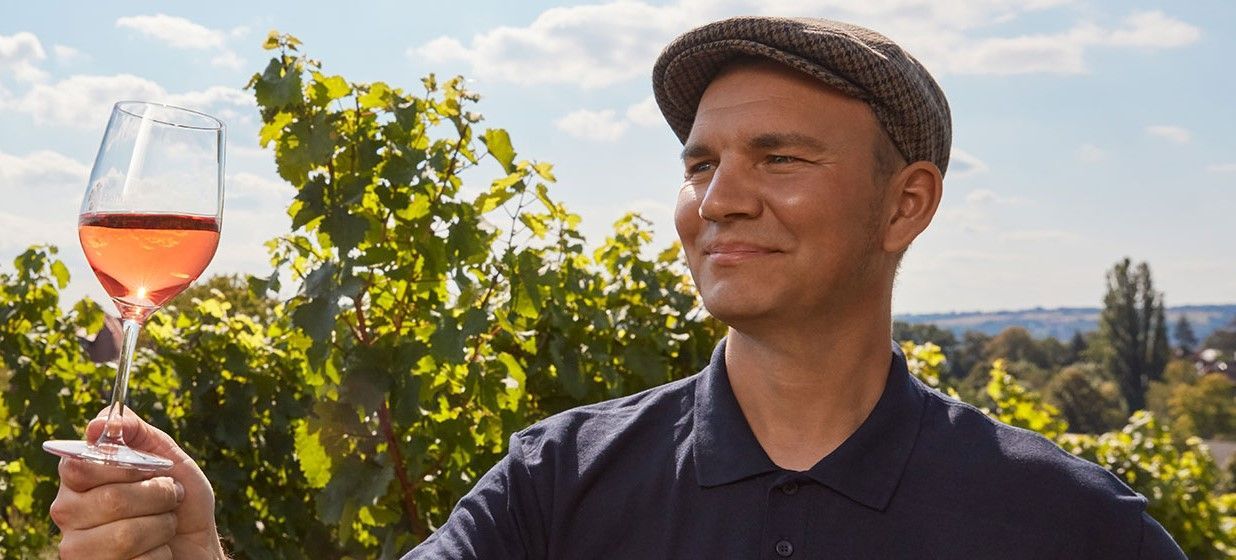 Weingut Hoflößnitz. Der Winzer taxiert seinen Wein. Es hat sich eine kleine Menge abgefüllt, hält es in die Sonne, um die Klaheit des Weins zu prüfen.