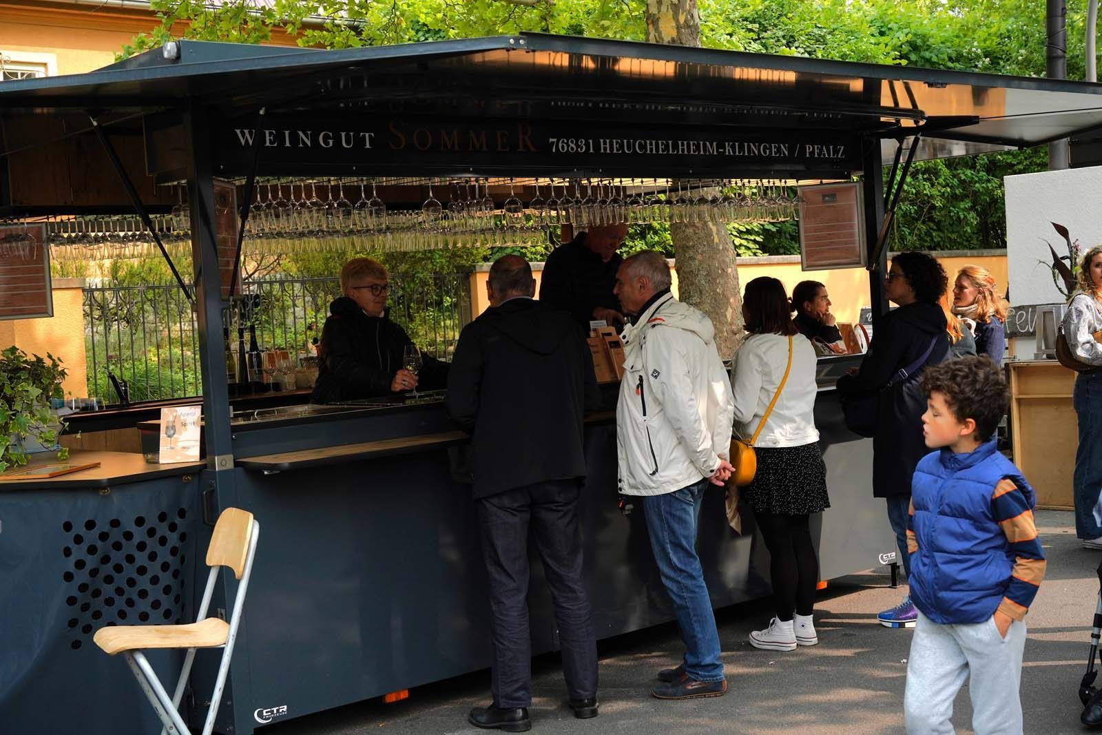 Besucher wählen am Weinwagen von Weingut Sommer ihren Lieblingswein bei WeinPfingsten 2025 in Westend