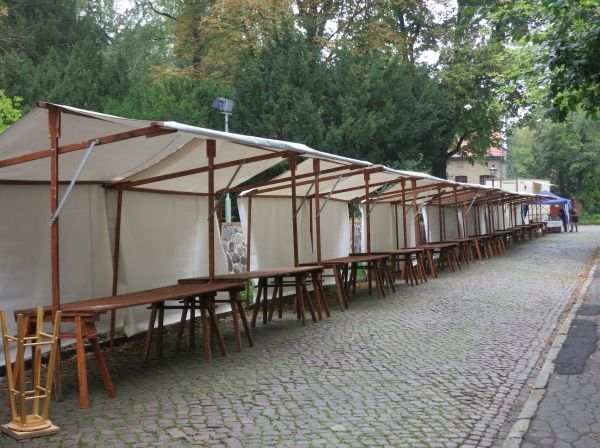 Reihe leerer Marktstände vor Veranstaltungsbeginn, ruhige Aufbauszene im frühen Stadium eines Markts