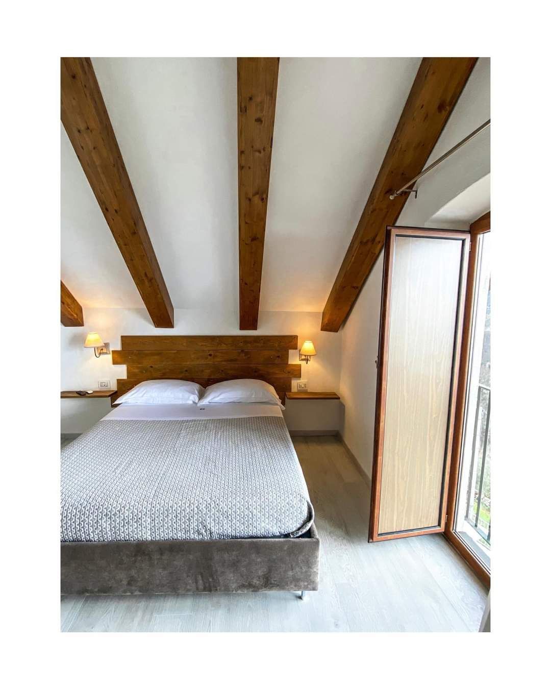 Camera da letto con travi in legno sul soffitto.