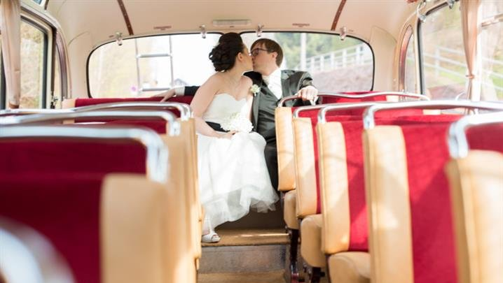 Hochzeitskuss im Nodtalgiebus: Und gleich steigen die Hochzeitsgäste in den Bus mit ein. Nostalgiebus mieten München