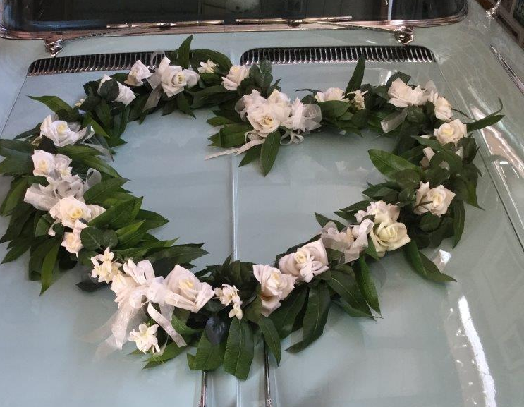 Das Herz mit rosafarbenen Blumen auf der türkisfarbenen Motorhaube hat der Florist schön gemacht. Blumenschmuck Hochzeitsauo Blumenherz Bilder