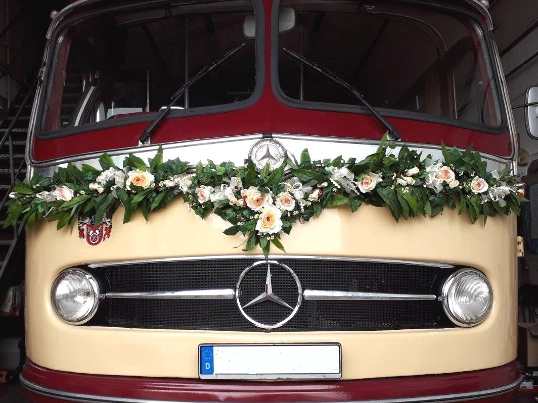 Als Hochzeitsbus bekommt der Oldtimerbus eine Blumen-Dekoration. Eine Girlande vorne entlang der Windschutzscheibe ist unsere Empfehlung. Dekoration Oldtimerbus