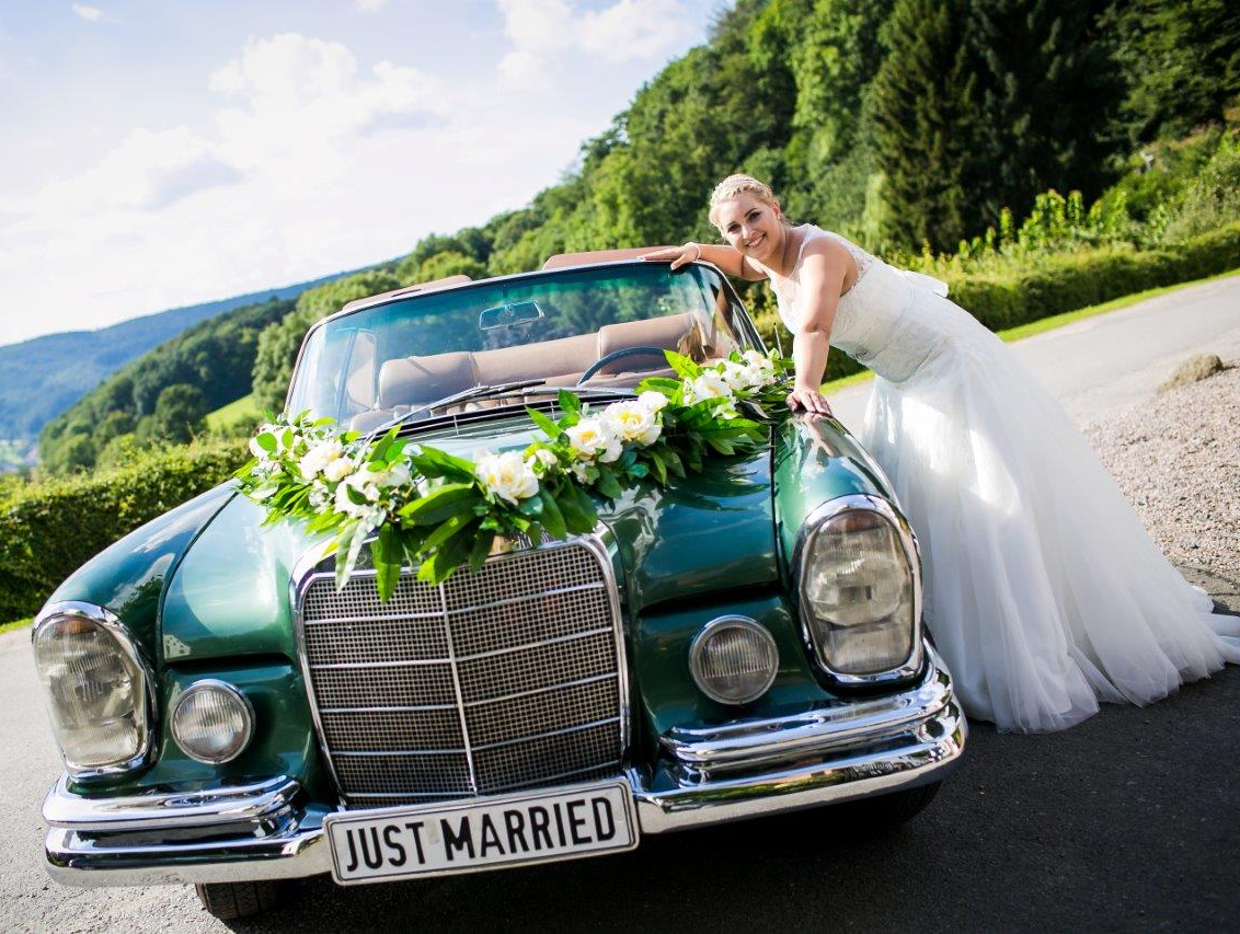 Schöne Bilder vom Hochzeitsfotografen und dem Hochzeitsauto mit Blumenschmuck. Hochzeitsauto Blumenschmuck Bilder