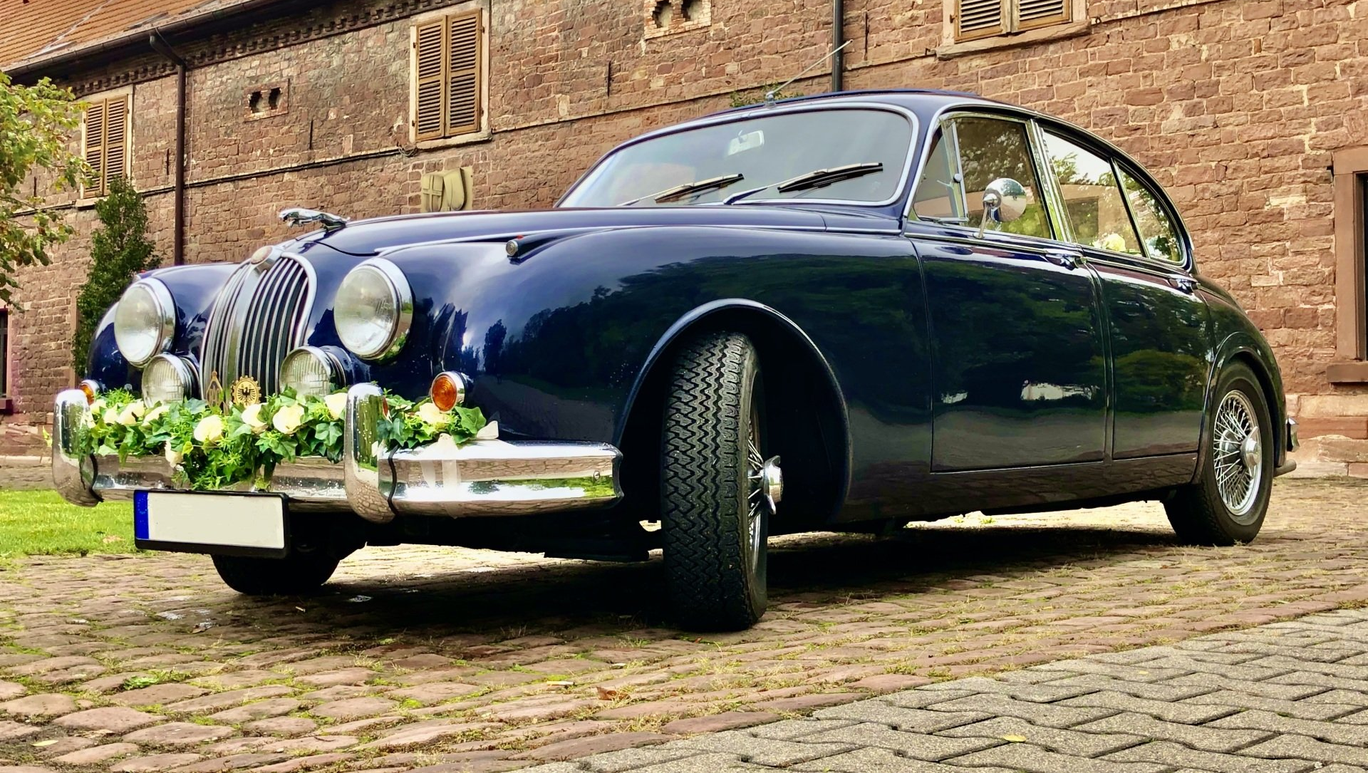 Zu einem Hochzeitsauto gehört u. E. ein Blumenschmuck einfach dazu. Das Auto / der Oldtimer soll ja als Hochzeitsauto erkannt werden. Die Blumendeko bzw. der Autoschmuck machen ein Auto erst zu einem Hochzeitsauto. Hochzeitsauto Blumenschmuck