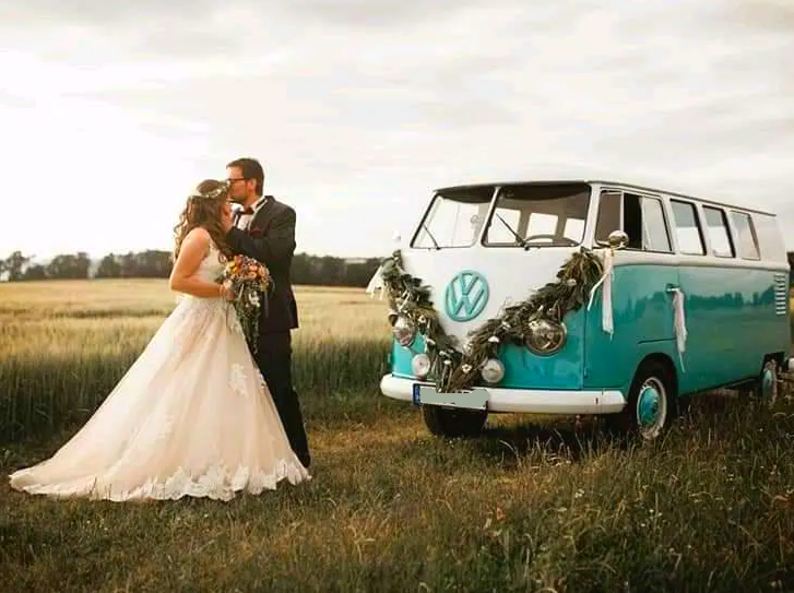 Passt wunderbar zum Brautpaar und der Landschaft: Der tükisfarbene T1 Bulli, einer der ersten VW Busse. Hochzeitsfotos mit dem VW Bus im Blumenschmuck.