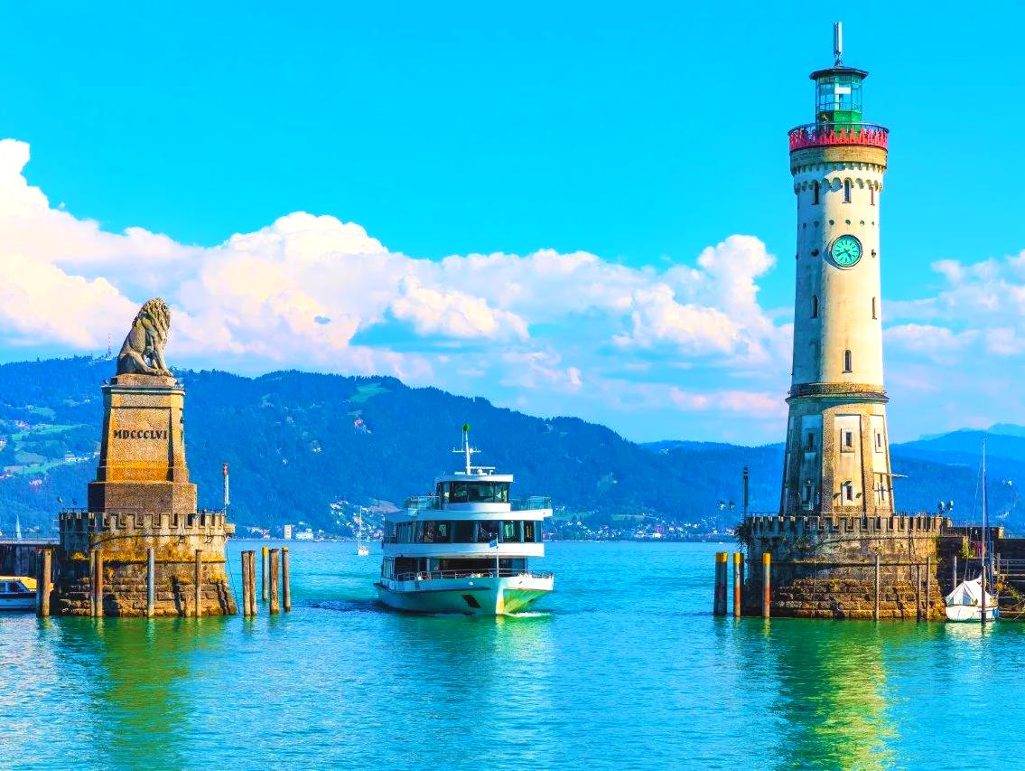 Oldtimer mieten Lindau: Der Hafen von Lindau mit dem bayrischen Löwen und dem steinernen Leuchtturm ist das Wahrzeichen dieses reizvollen Städtchens am Bodensee. Oldtimer mieten Lindau