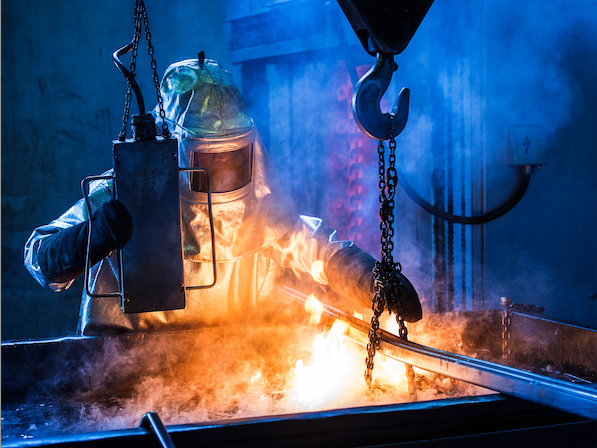 A foundry worker is quenching casts in an oil bath (Shutterstock)