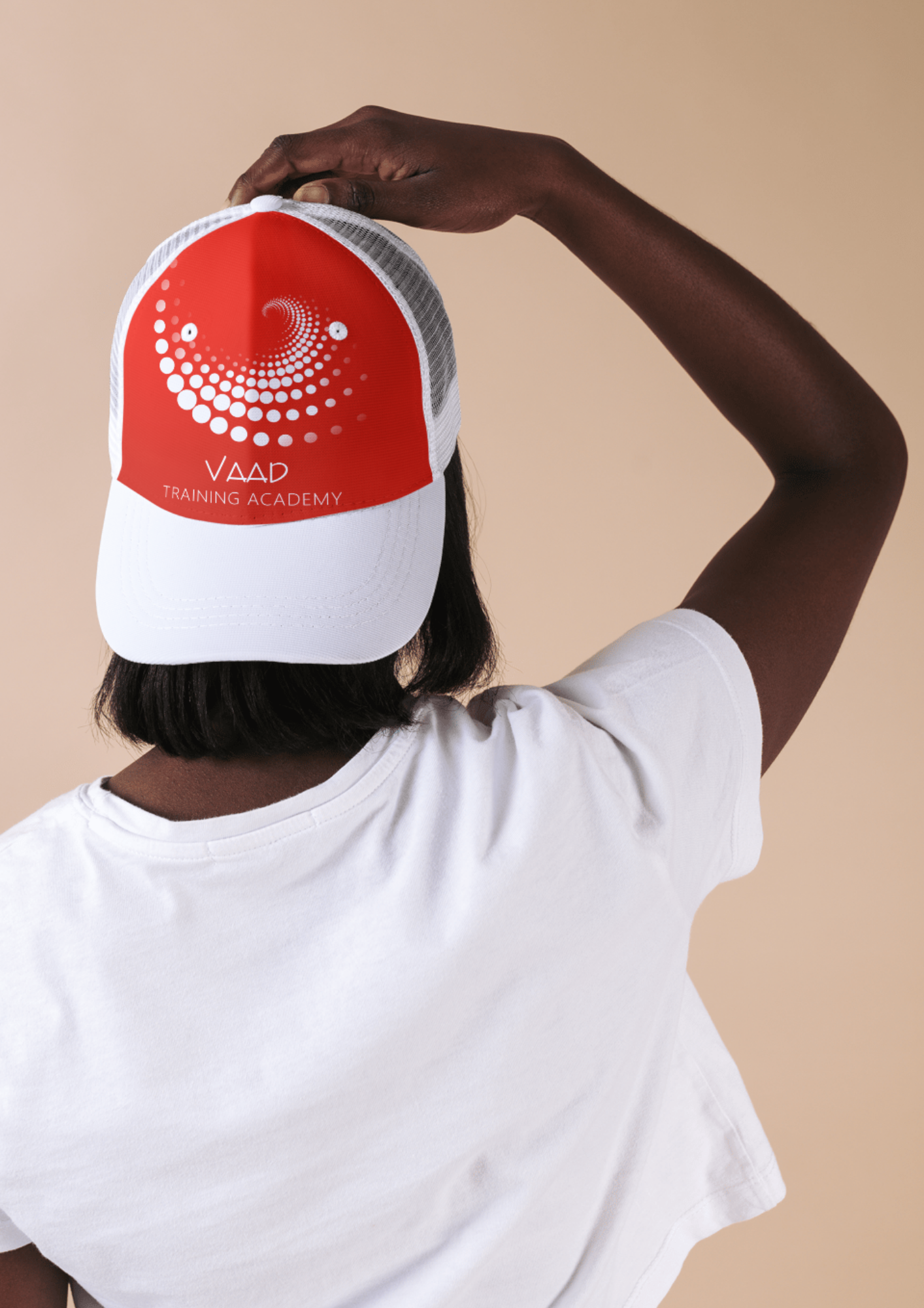 The back of a womans head wearing a white cape with the VAAD logo