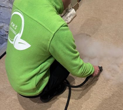 Notre agent d'entretien qui désinfecte une moquette à la vapeur sèche