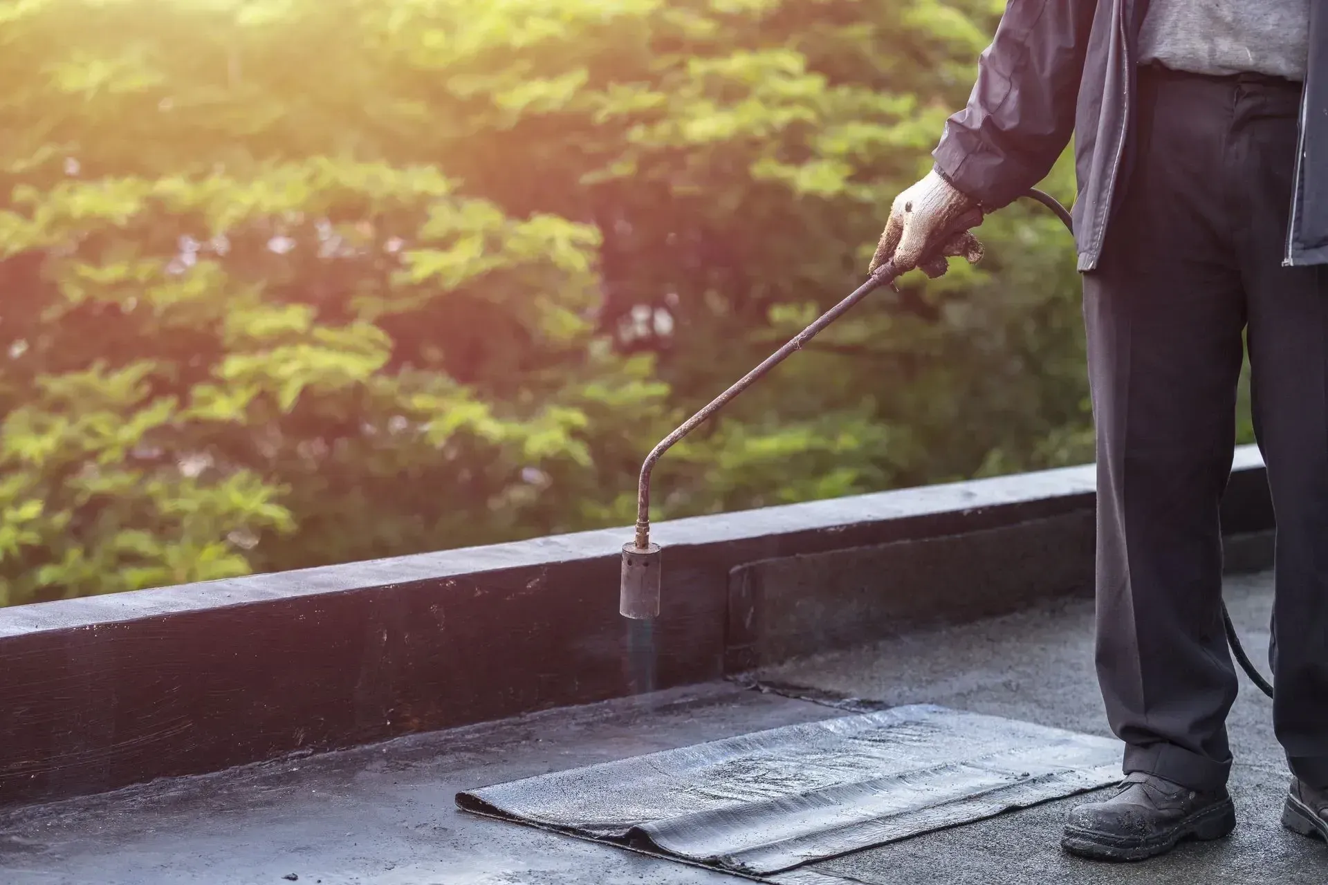 Rénovation de toit avec un professionnel utilisant un chalumeau