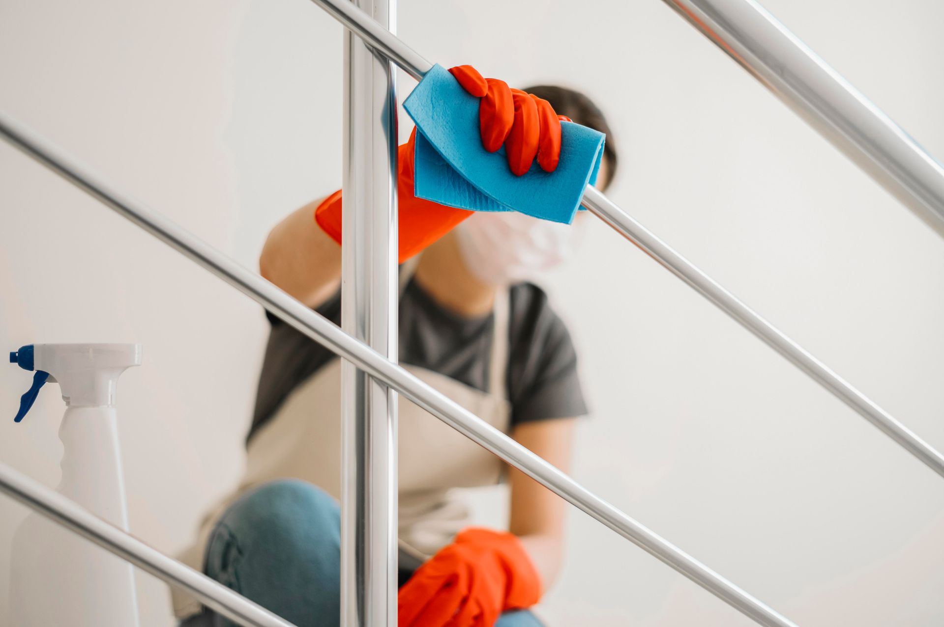 Femme de ménage qui dépoussière une rampe à l'aide d'un chiffon