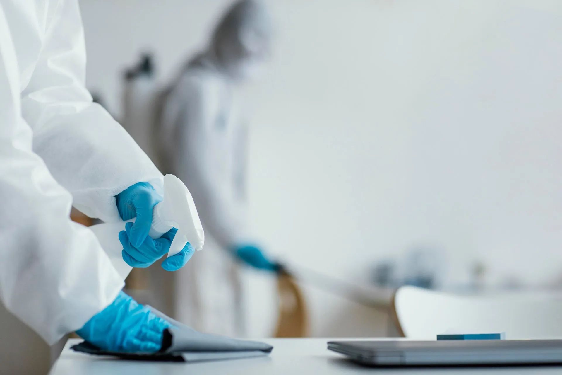 Homme qui nettoie les surfaces d'un bureau