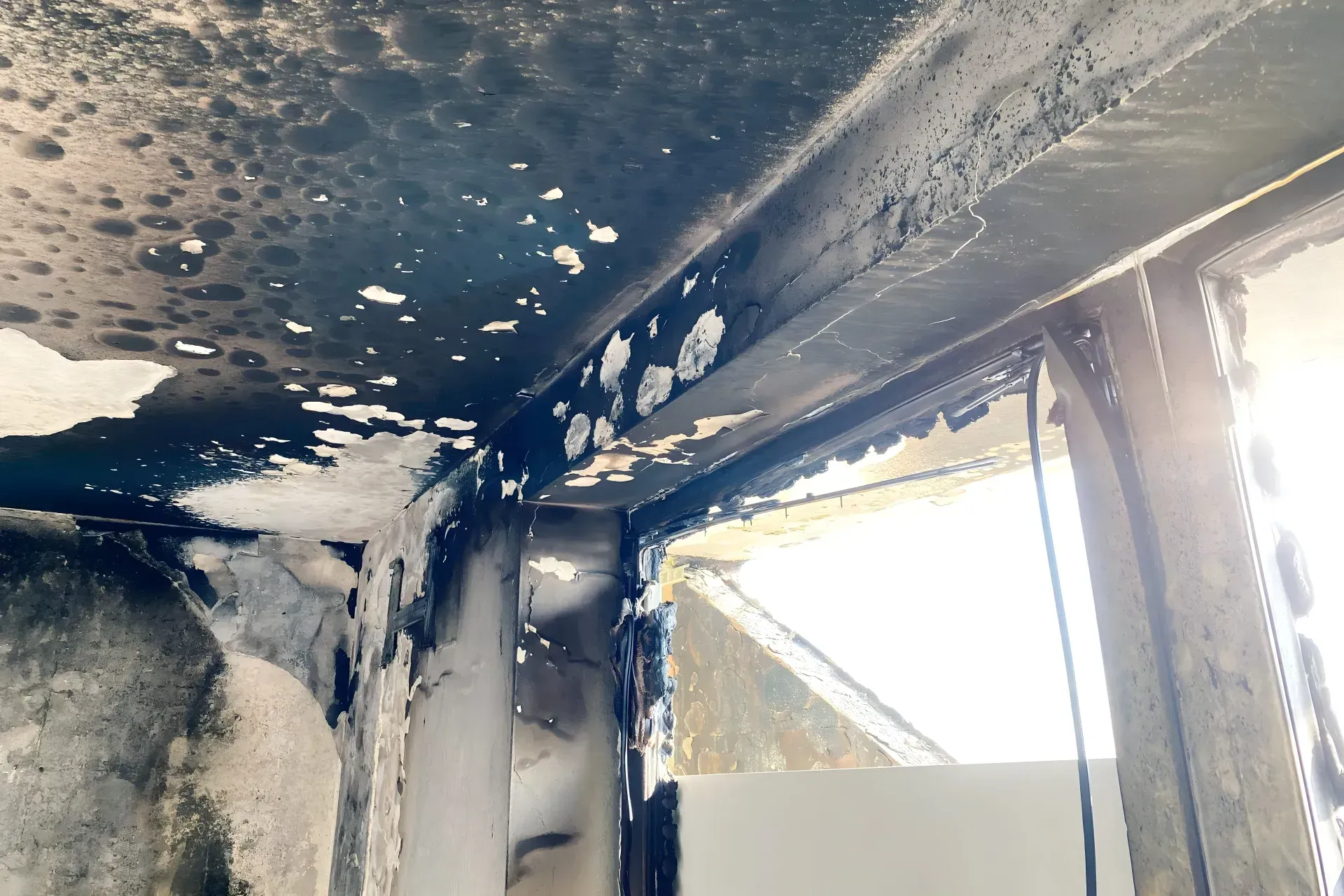 Plafond noirci et endommagé après un incendie, montrant des signes de brûlure