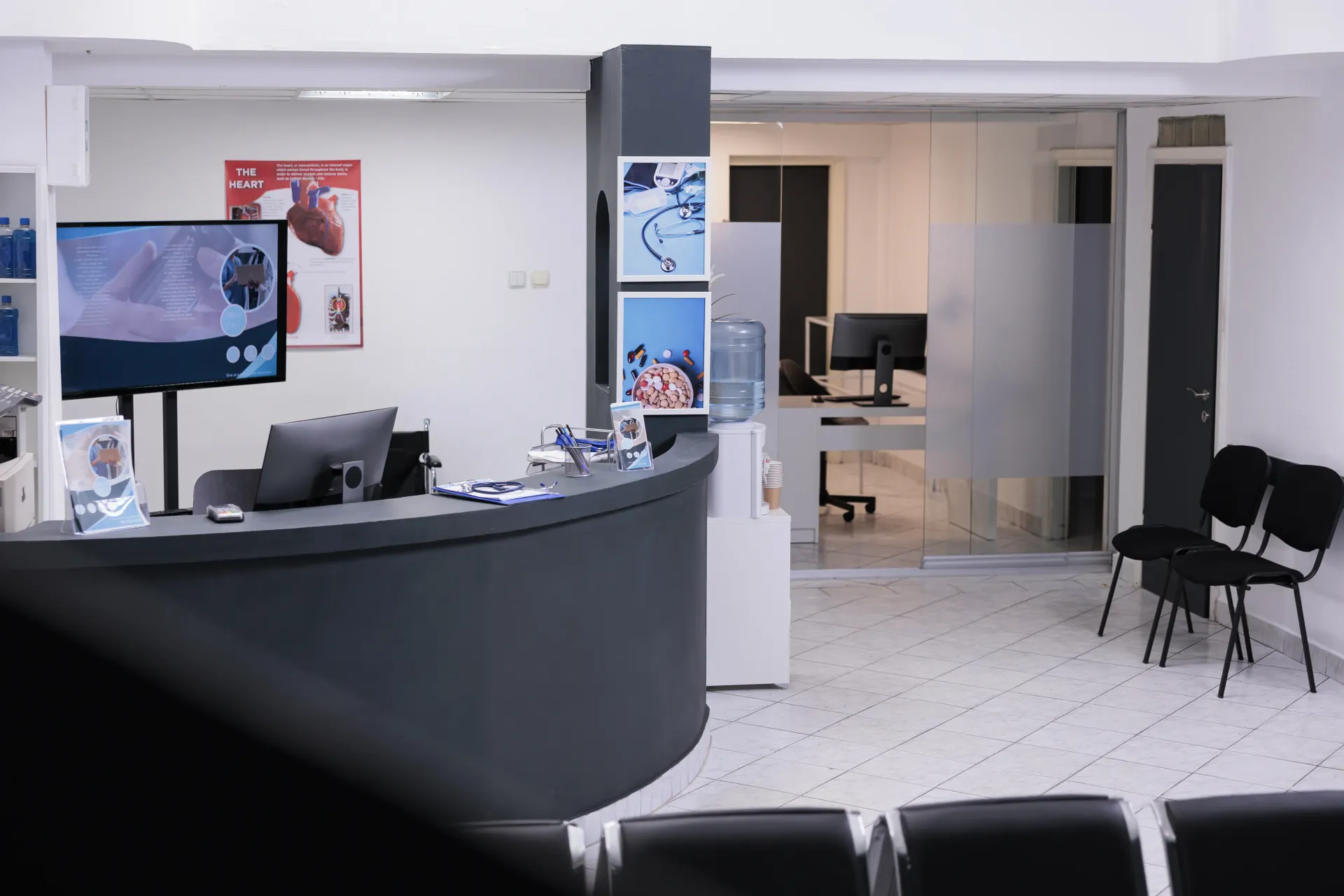 Bureau-d'acceuil-d'un-centre-hospitalier-avec-un-bureau-noir-et-des-écran-ordinateur-entouré-de-siège-d'anttente