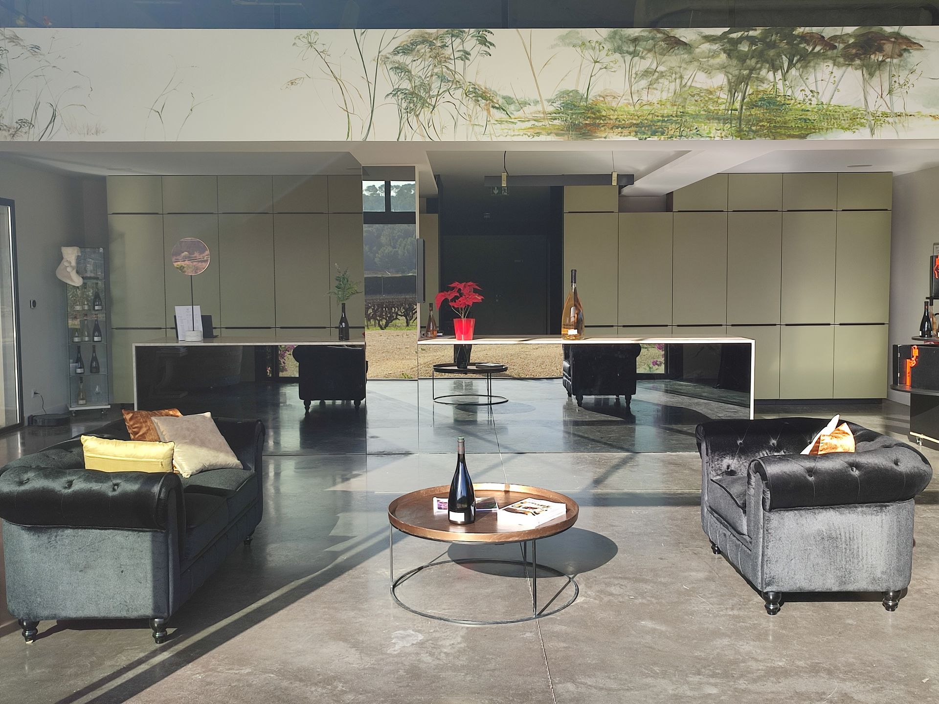 Photo du magasin au Domaine Pieracci avec canapés en velours, comptoir moderne et vue sur le vignoble.
