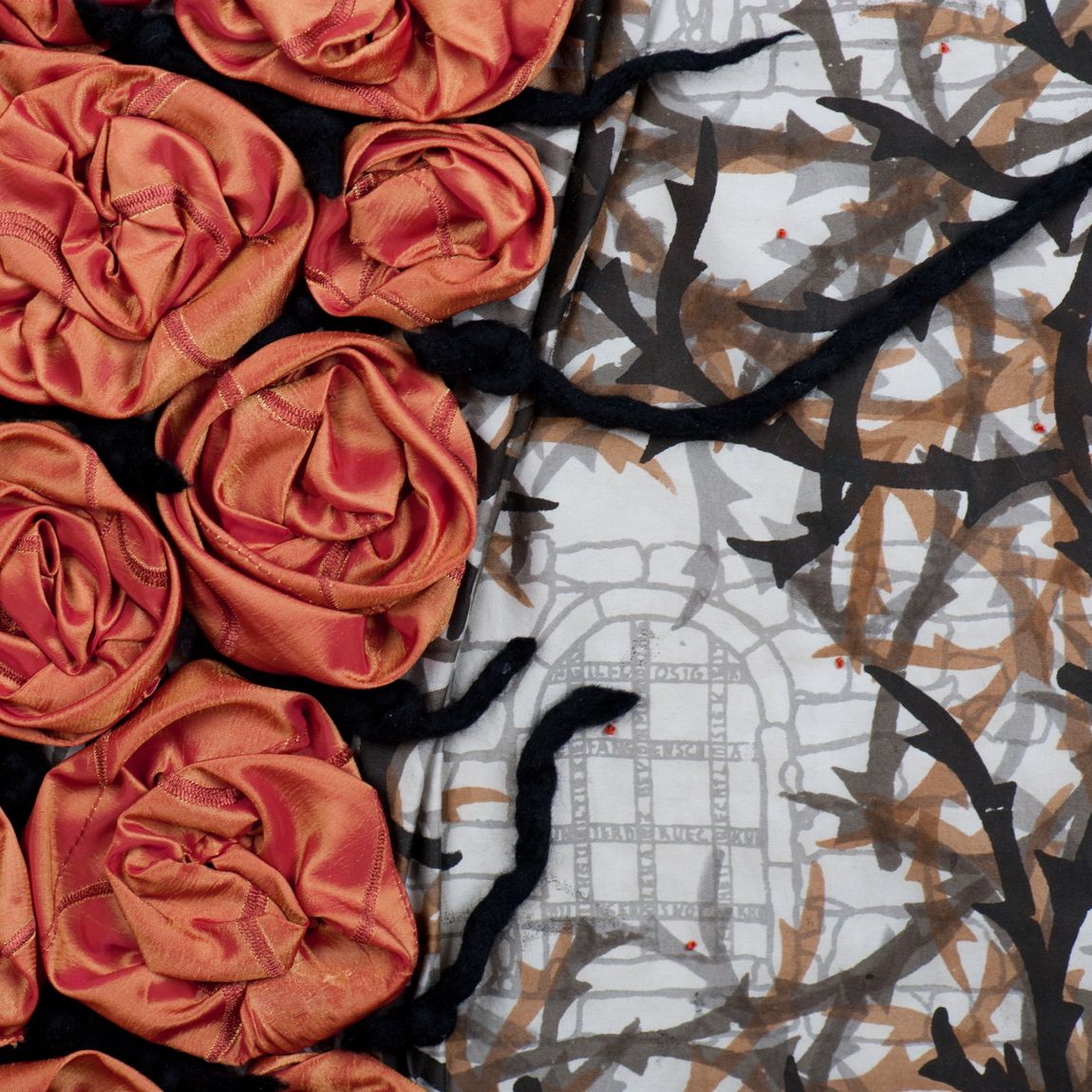Baumwollstoff mit Mauerwerk und Dornenranken bedruckt, darauf orangefarbene Rosen appliziert
