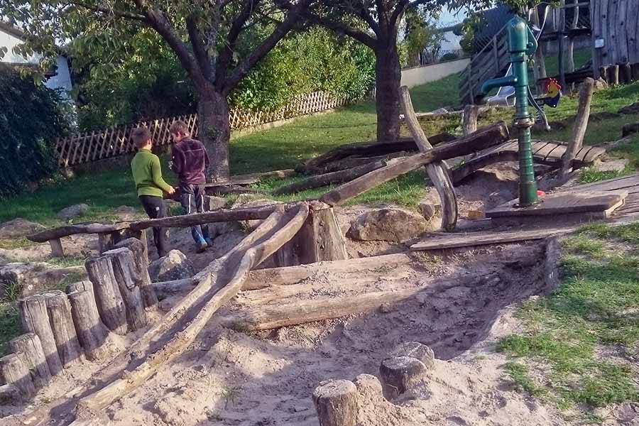 Spielende Kinder am Wasserspiel des Naturspielplatzes Göcklingen Naturspielplatz Göcklingen