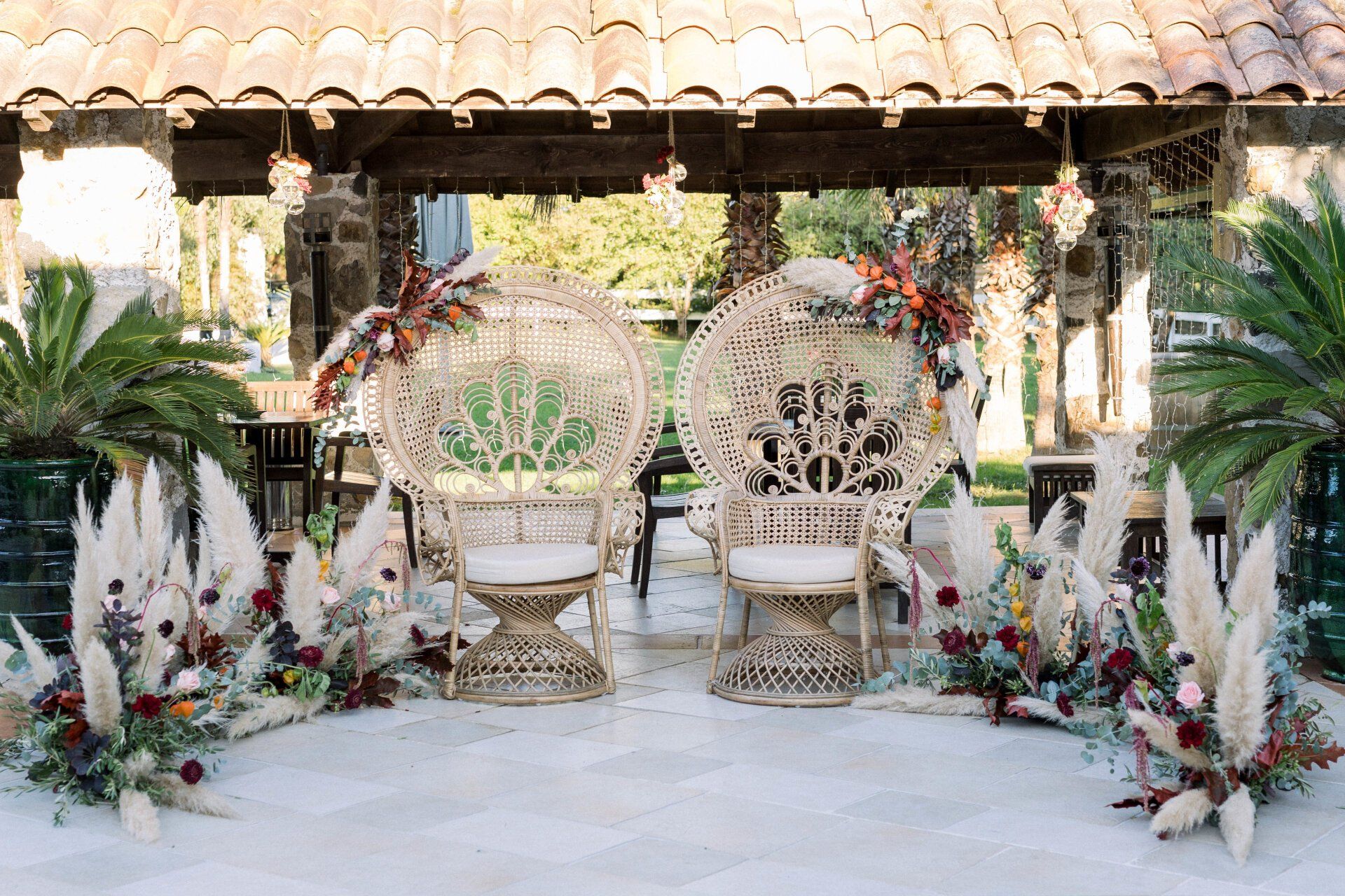 Photo d'une décoration de mariage par Emi Wedding - un demi arc de cercle floral entoure deux fauteuils Emmanuelle, compositions florales automnales, scénographie Emi Wedding