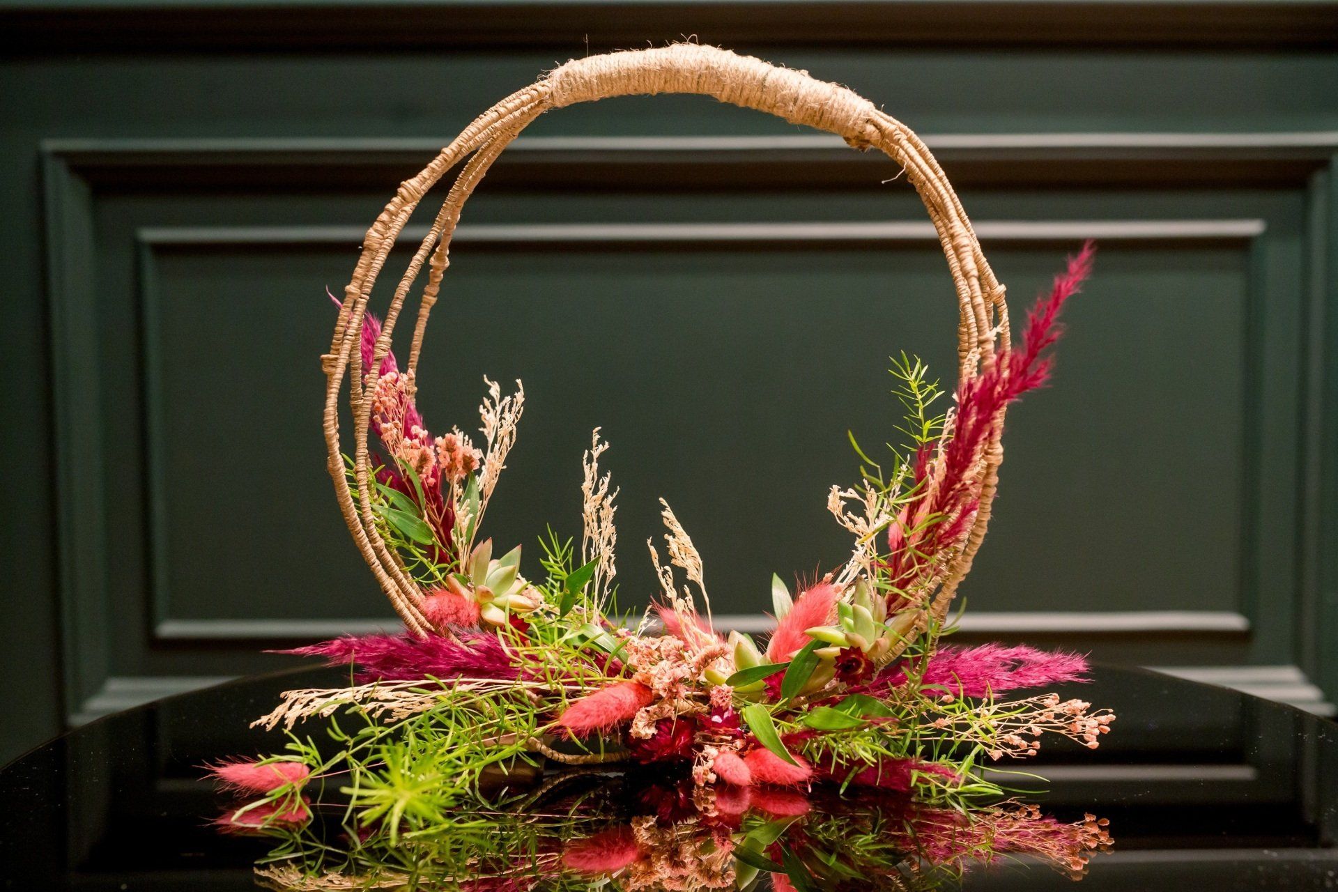 Bouquet de mariée original, bouquet sac à main rond, en osier, fleurs fushia et beige, feuillage vert.