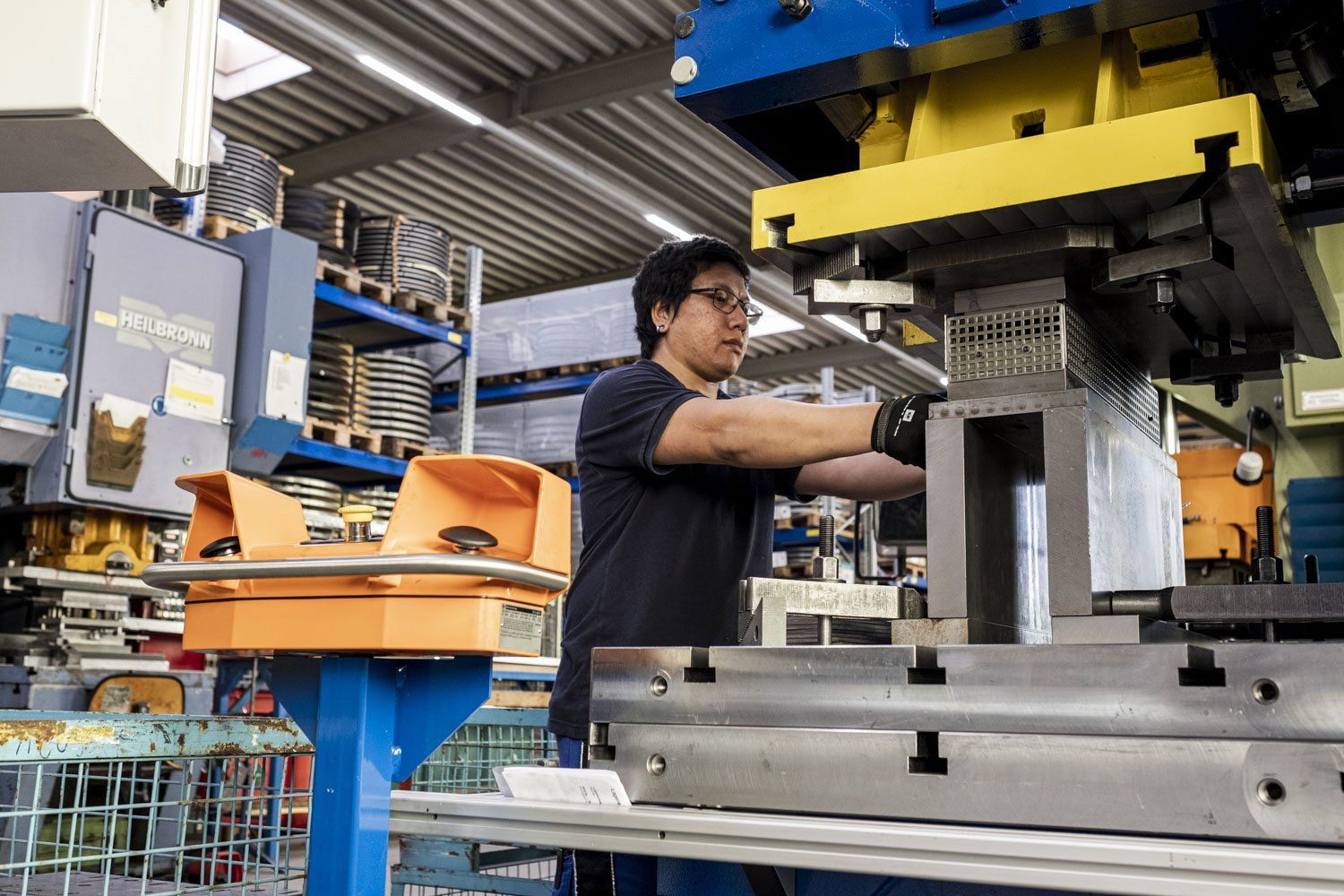 Einblick in die Werkstatt Junger Mann arbeitet an einer Maschiene