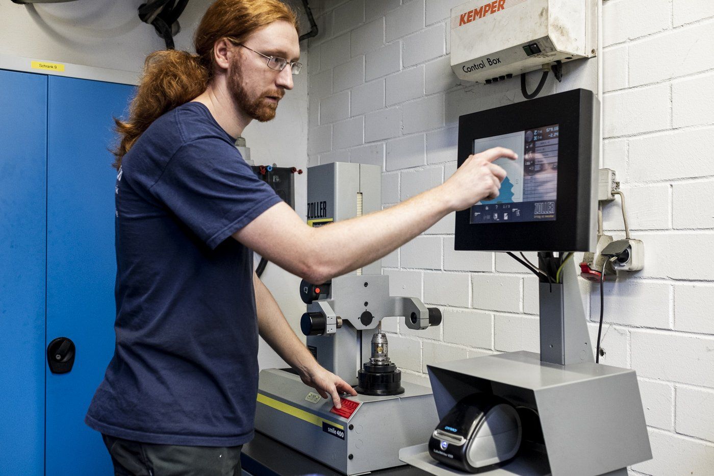 Junger Mann beim Eintippen von Daten in einen Maschinencomputer.
