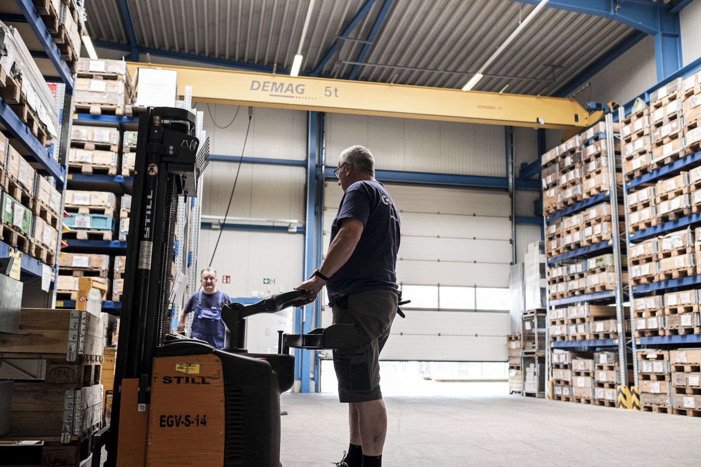 Zwei Männer arbeiten in einer Logistikhalle.