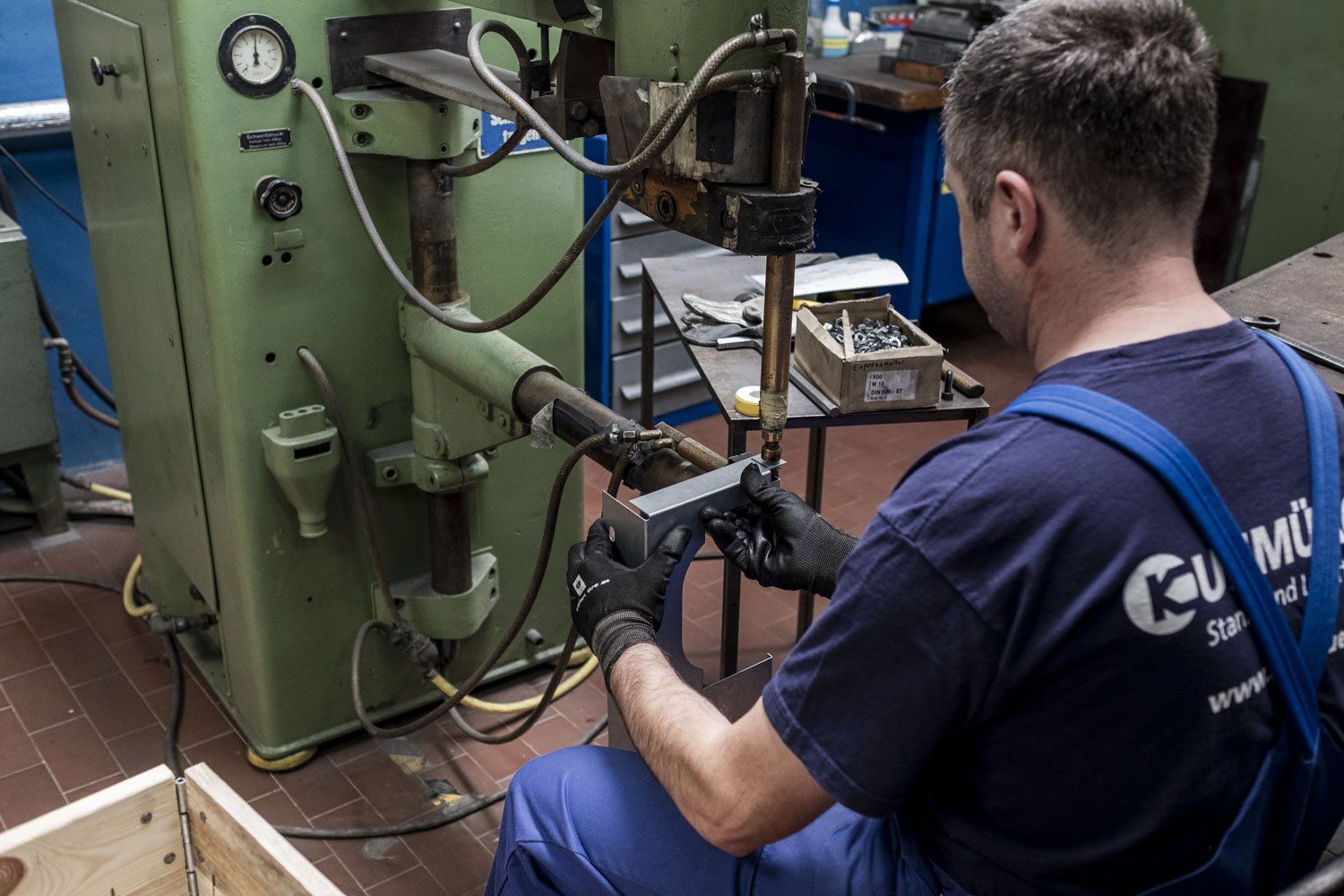 Ein Mann bedient, mit dem Rücken zum Betrachter eine Maschine.