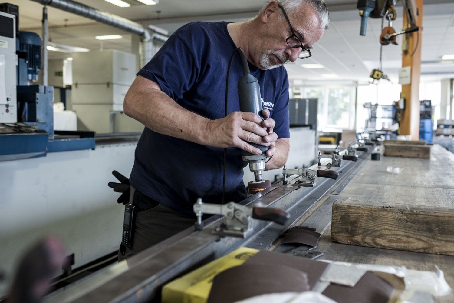 Ein Mann poliert, in der Werkstatt, einen Gegenstand.