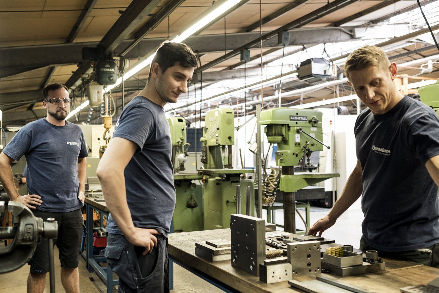Zwei Männer beobachten einen dritten, während dieser etwas ausprobiert.