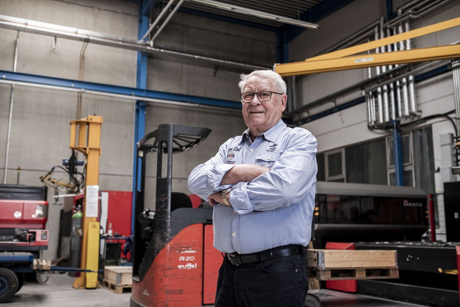 Ein freundlicher Mann steht in einer Logistikhalle.