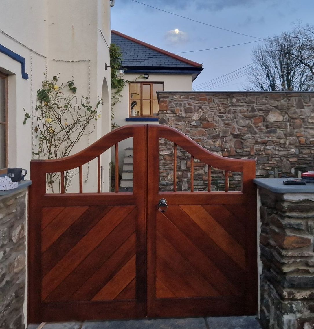 Iroko gates with swept gull wing top with 22mm iroko dowel bar work and TGV boards at 45deg 