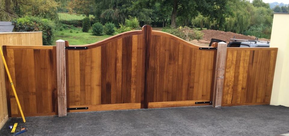 large pair of Iroko gates with swept gull wing heads 