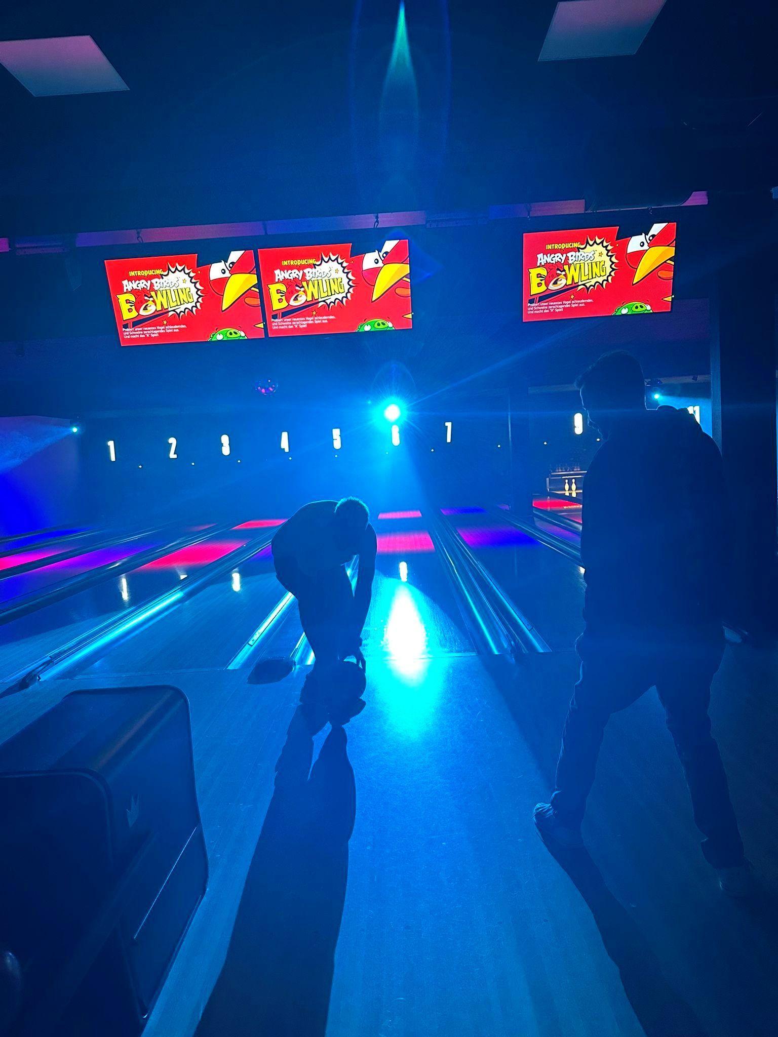 Mitarbeitende spielen Bowling bei der Weihnachtsfeier.
