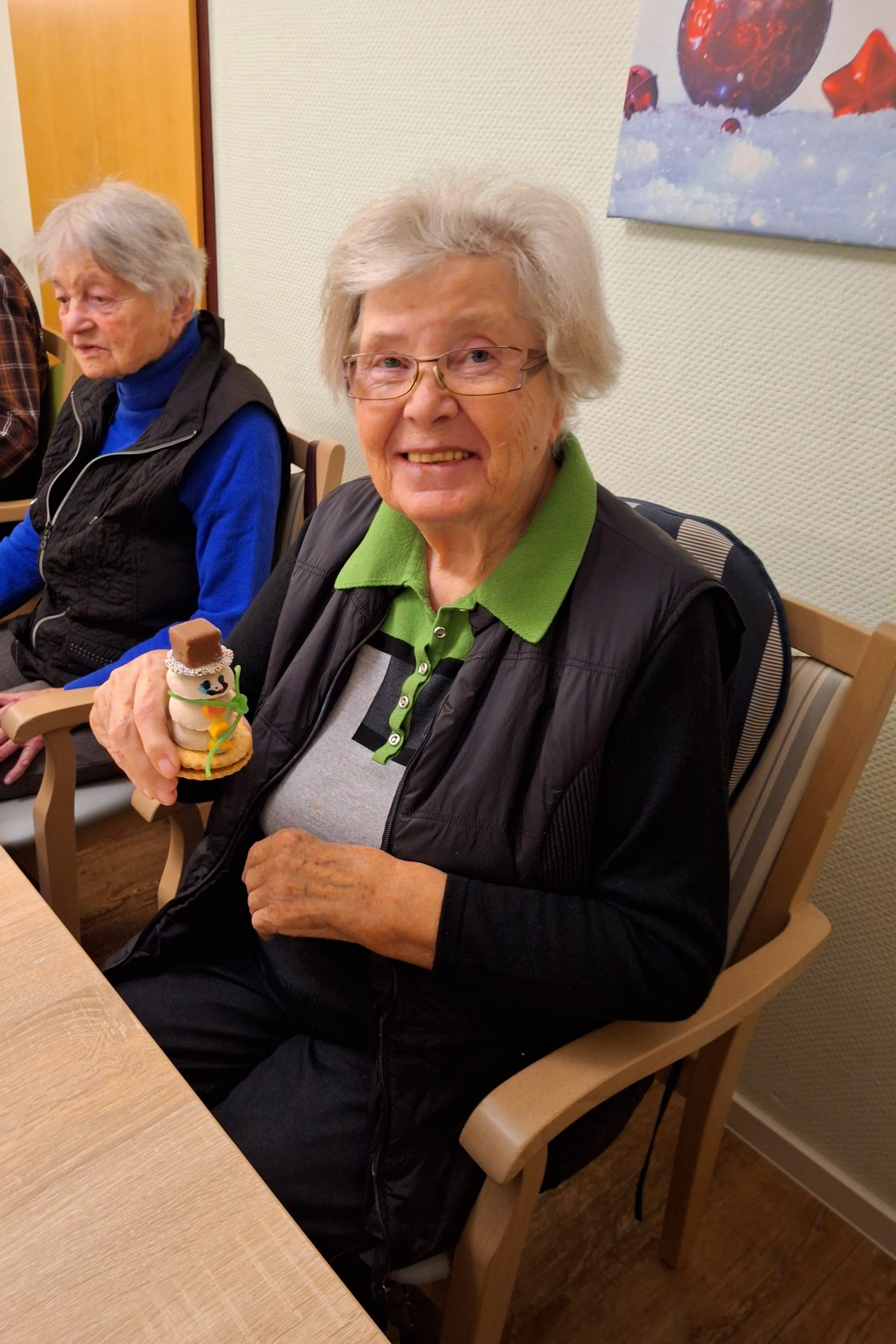Seniorin mit weihnachtlicher Bastelarbeit.