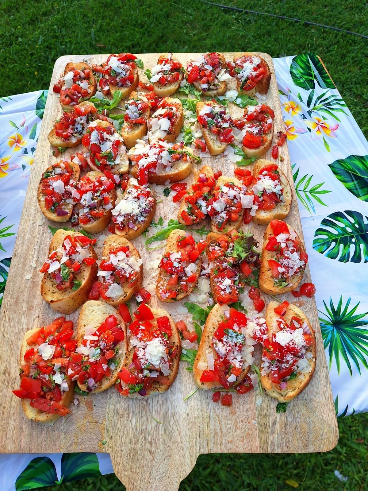 Bruschetta mit Tomaten auf einem Holzbrett beim Sommerbuffet.