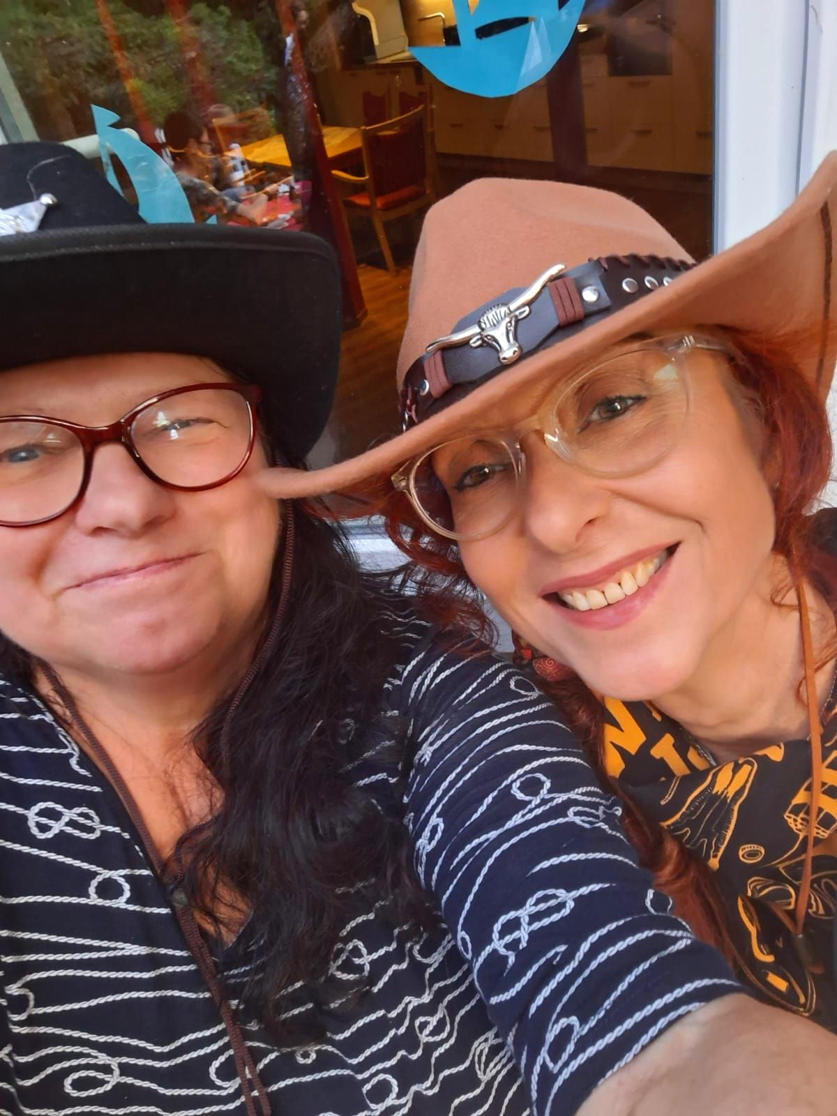Mitarbeiter und Bewohnerin machen gemeinsam ein Selfie beim Mitarbeiterfest im Garten.
