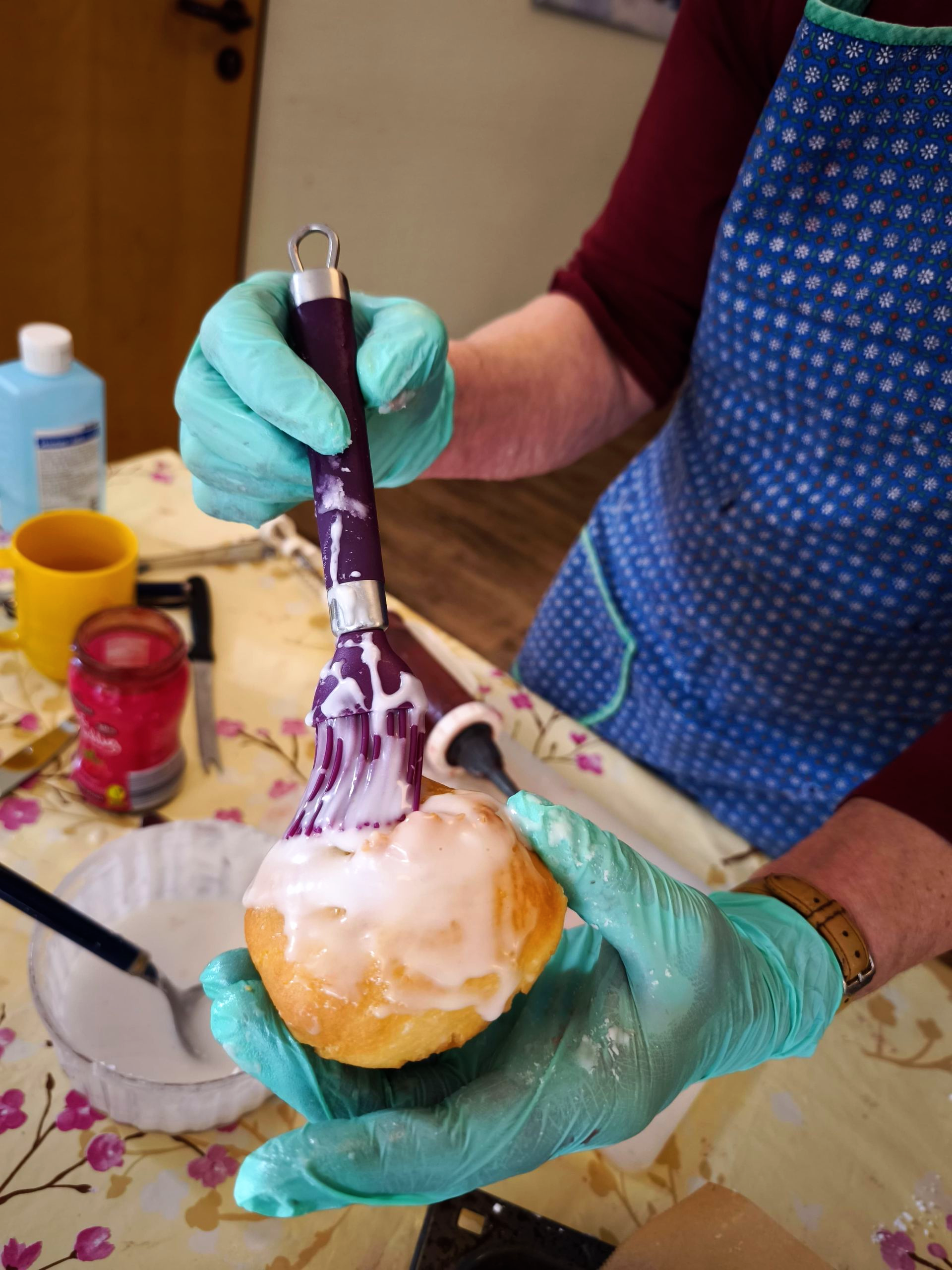 Ein Berliner wird mit Zuckerguss bestrichen.