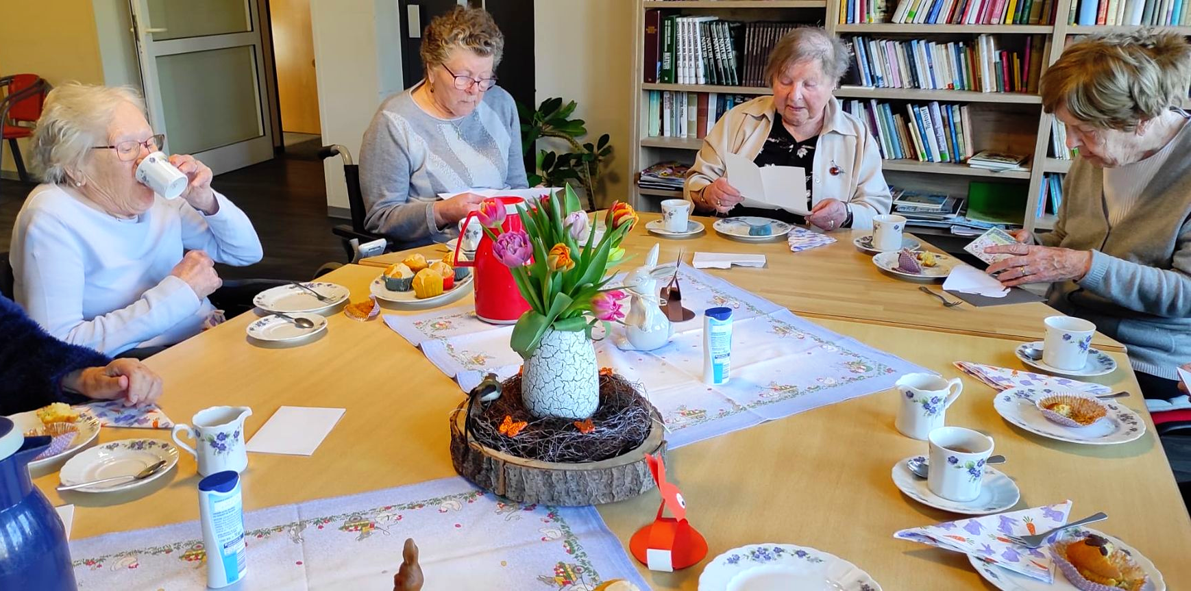Bewohnerinnen sitzen gemeinsam an einer gedeckten Kaffeetafel im Lambertistift Oldenburg und genießen die Osterzeit.