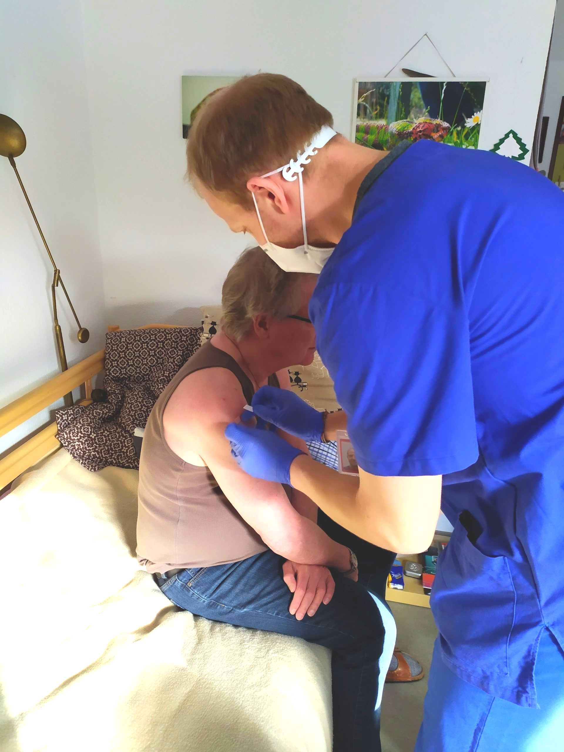 Impfteam impft einen Bewohner in seinem Zimmer bei der 2. Corona-Impfung.