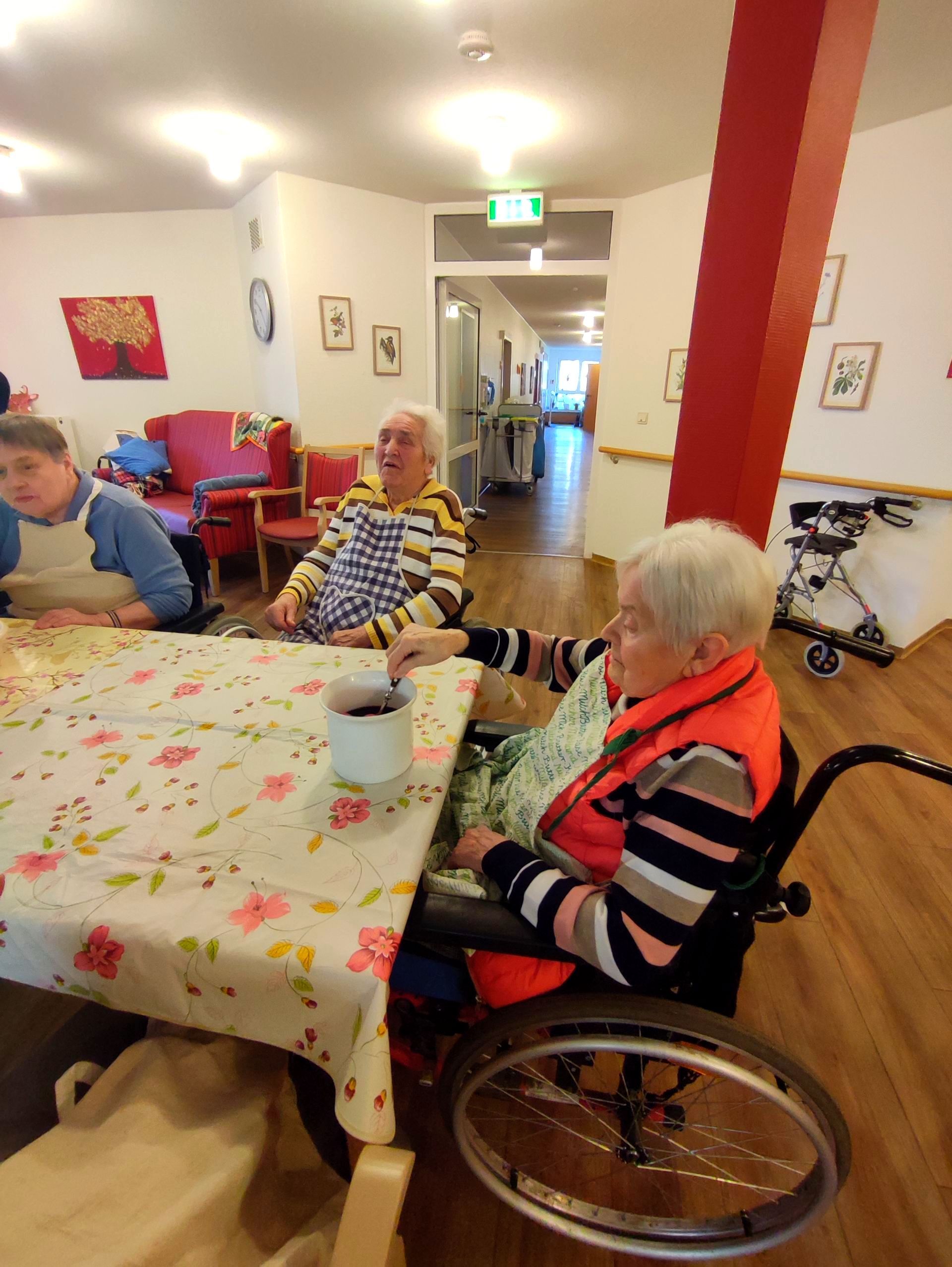 Bewohnerinnen sitzen zusammen am Tisch und färben Ostereier im Aufenthaltsraum des Lambertistifts.