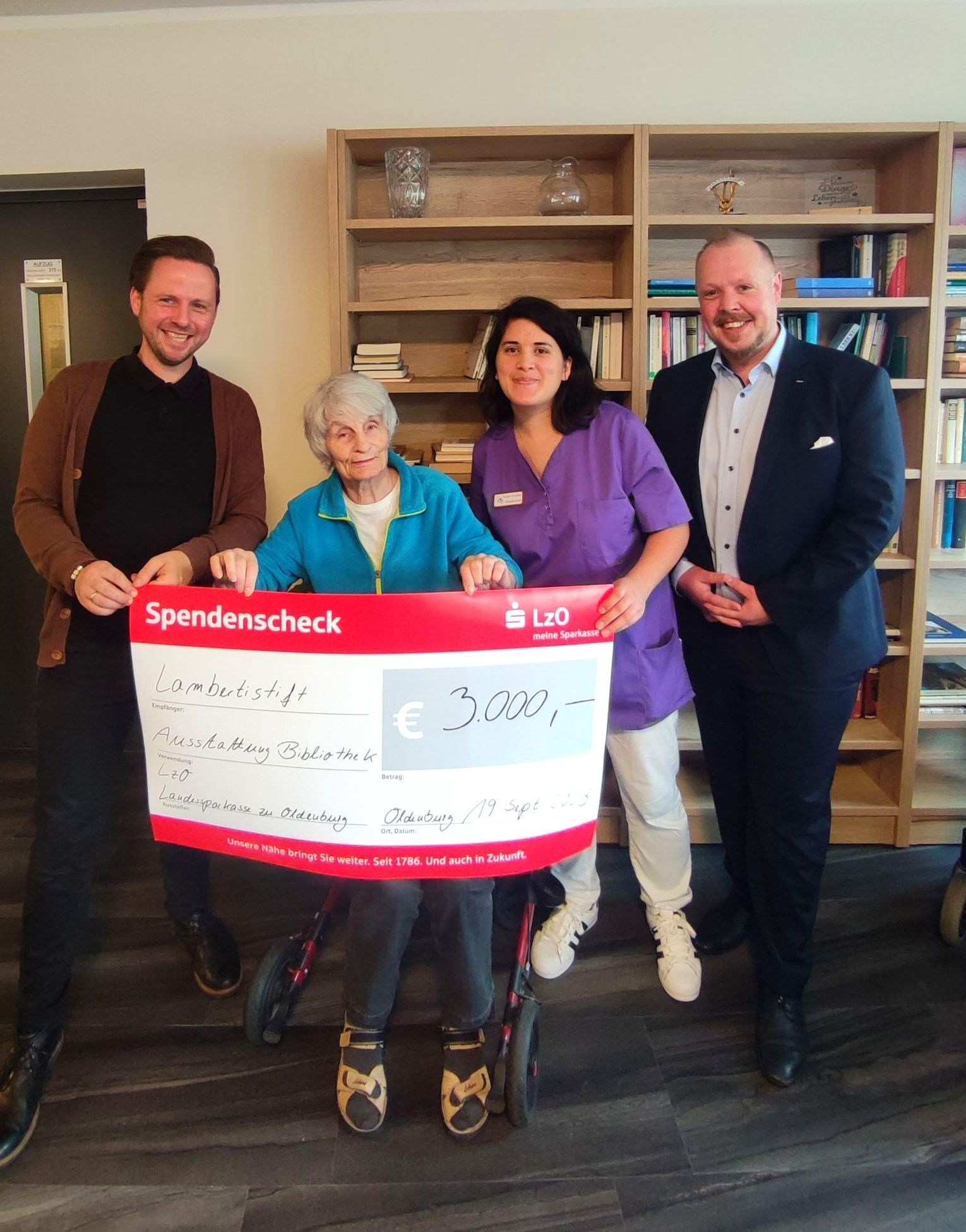 Bewohnerin und Mitarbeitende des Lambertistifts nehmen Spendenscheck über 3.000 Euro von der LZO entgegen.