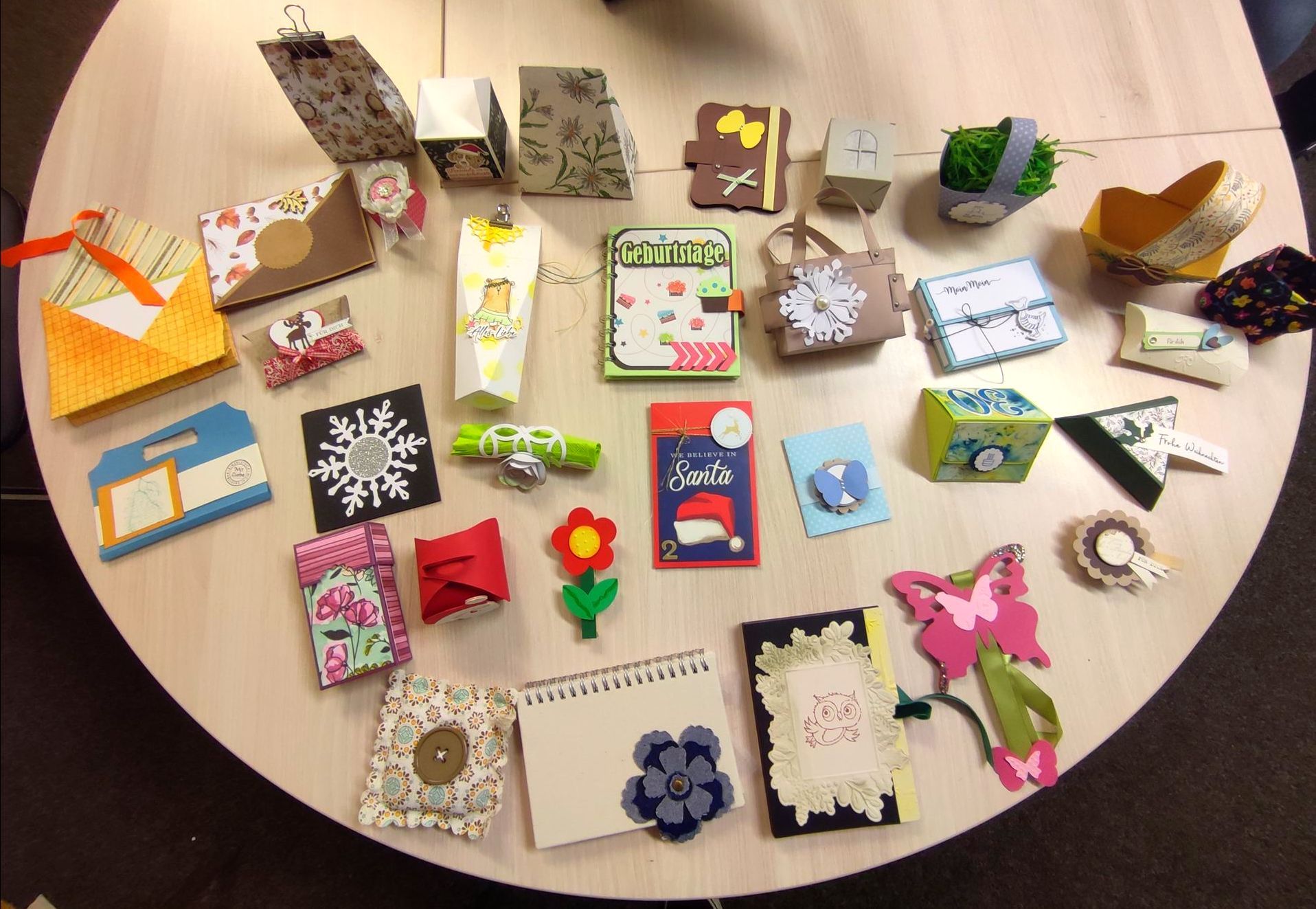 Übersicht verschiedener handgefertigter Bastelarbeiten und Geschenkverpackungen.