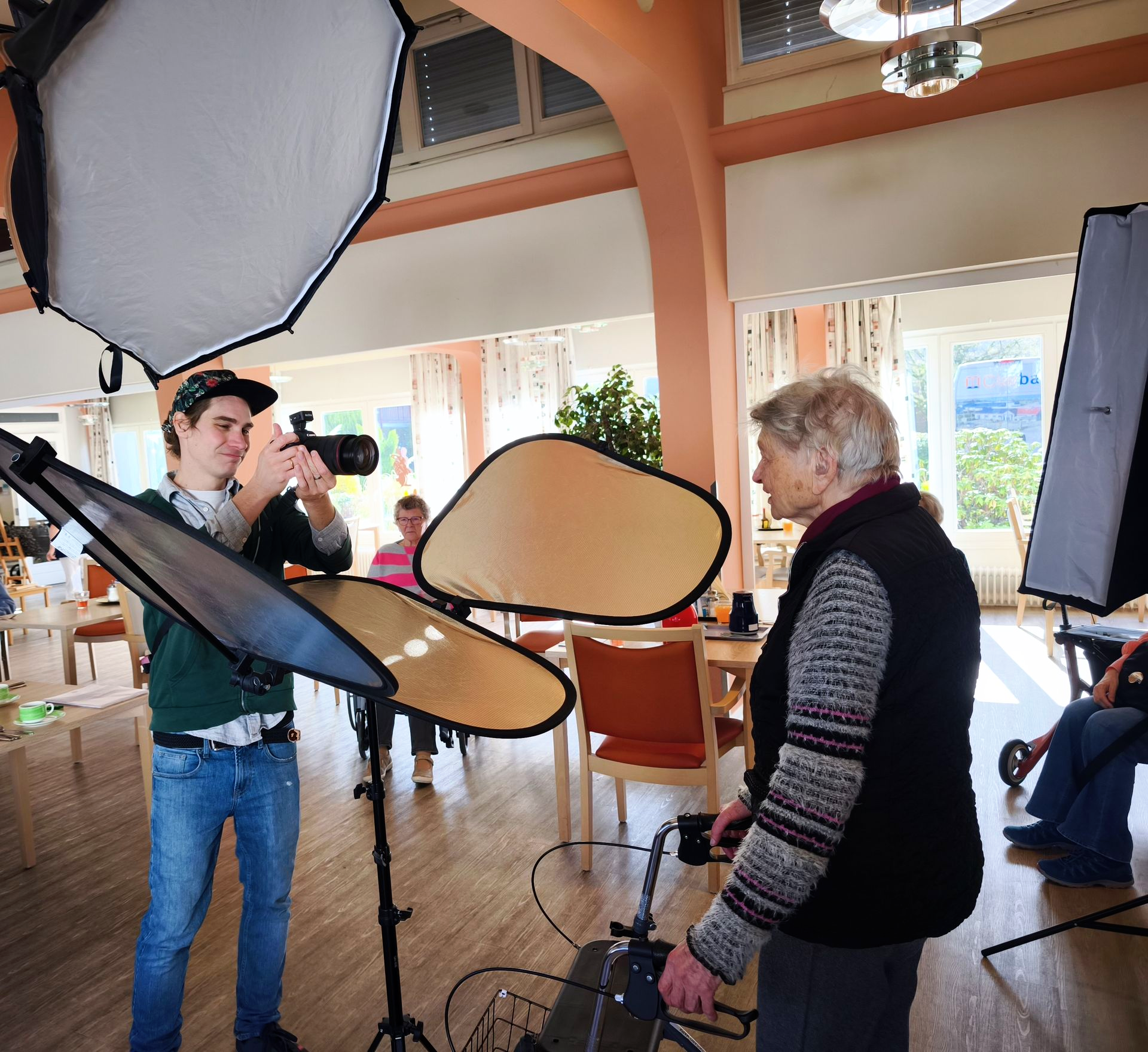 Bewohnerin mit Rollator beim Fotoshooting 2026 im Lambertistift vor Fotohintergrund.
