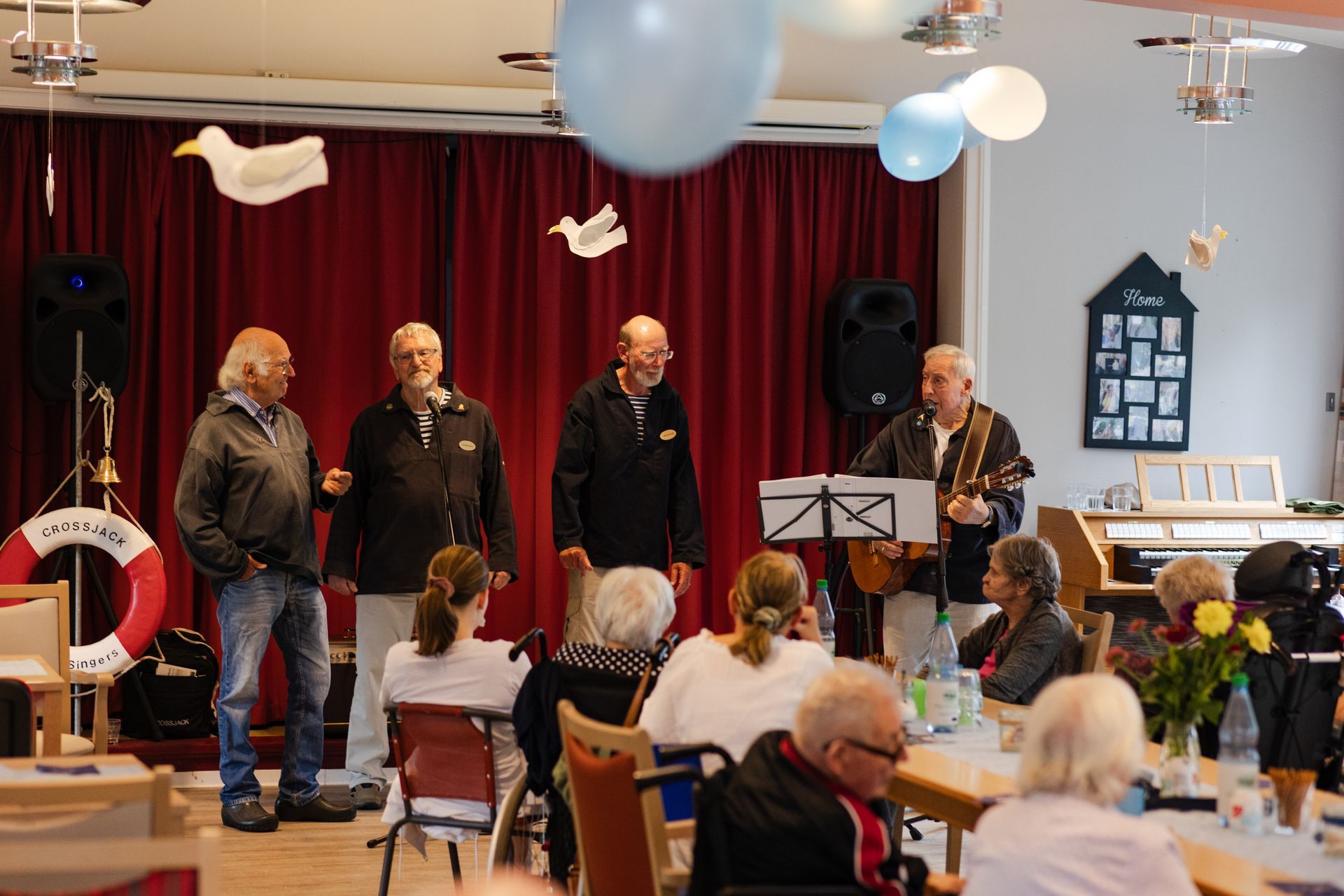 Musikgruppe tritt beim Sommerfest vor Bewohnern im Speisesaal auf.
